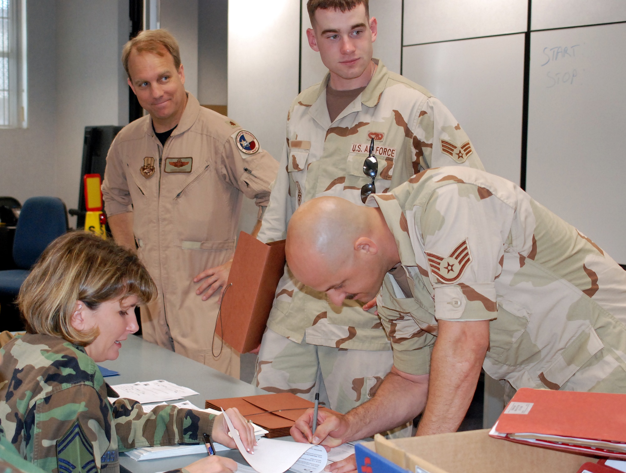Air Force Reserve Senior Master Sgt. Samantha Boswell, 301st Aerospace Medicine Squadron’s senior Air Reserve Technician, helps 301st Fighter Wing members to process through the deployment line before departing for Southwest Asia. Nearly 300 301st Fighter Wing troops deployed recently to support the current Aerospace Expeditionary Force cycles. (U.S. Air Force Photo/Tech. Sgt. Julie Briden-Garcia)