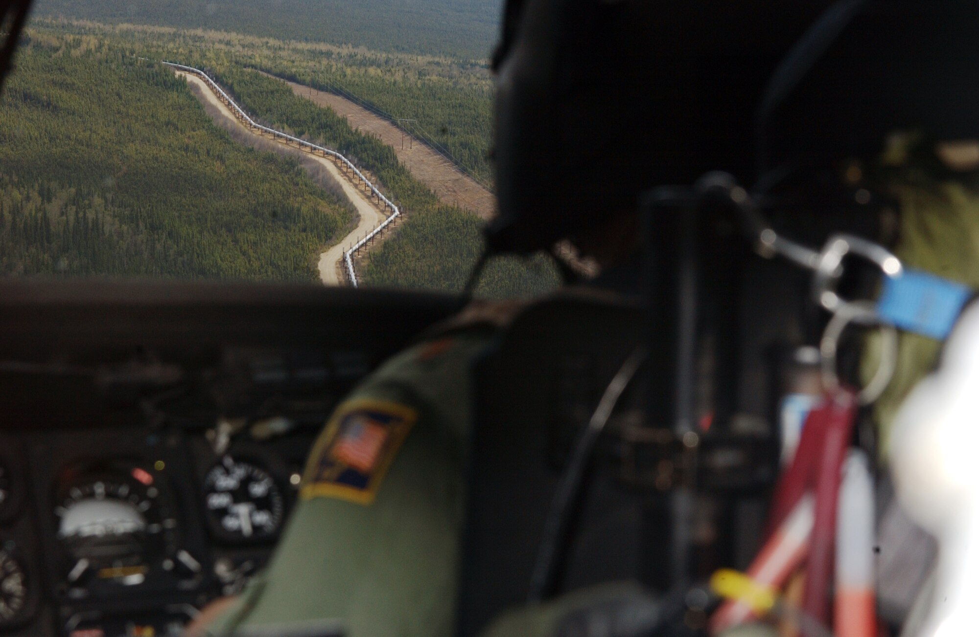 Maj. William Kupchin scans the terrain for suspicious activity over the Trans-Alaska Pipeline System May 10 during Northern Edge. The exercise is designed to practice operations, techniques and procedures, and enhance interoperability among all the services and civilian emergency response teams. Major Kupchin is a pilot assigned to Det. 1, 210th Rescue Squadron at Eielson Air Force Base, Alaska. (U.S. Air Force photo/Airman 1st Class Jonathan Snyder)
