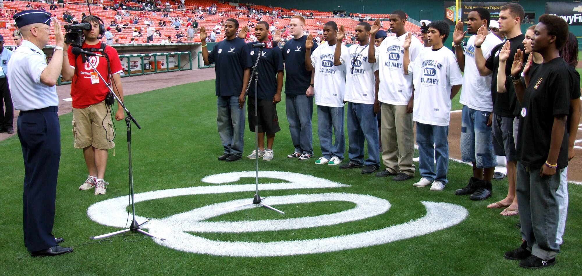 Twelve recruits -- three Air Force, five Navy and four Army -- take oaths of enlistment at a ceremony presided over by Lt. Gen. (Dr.) James G. Roudebush during pre-game Military Appreciation Night activities May 11 at Robert F. Kennedy Stadium in Washington, D.C. General Roudebush is the Air Force surgeon general. (Department of Defense photo/Gerry J. Gilmore)
