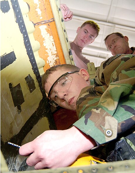 Under the watchful gaze of Senior Airman Pete Young and Tech. Sgt. Rob Exendine, 442nd Maintenance Squadron structures shop, fellow shop member Airman Bradley Dalton, inserts a drill bit into a power drill as he works to replace a badly-corroded floor panel in A-10 Thunderbolt II aircraft number 237. The 442nd Fighter Wing reservists were tasked to remove a corrosion-degraded floor panel then fabricate and install a replacement, a task usually performed by technicians at the Ogden Air Logistics Center at Hill Air Force Base, Utah. (US Air Force photo/Master Sgt. Bill Huntington)