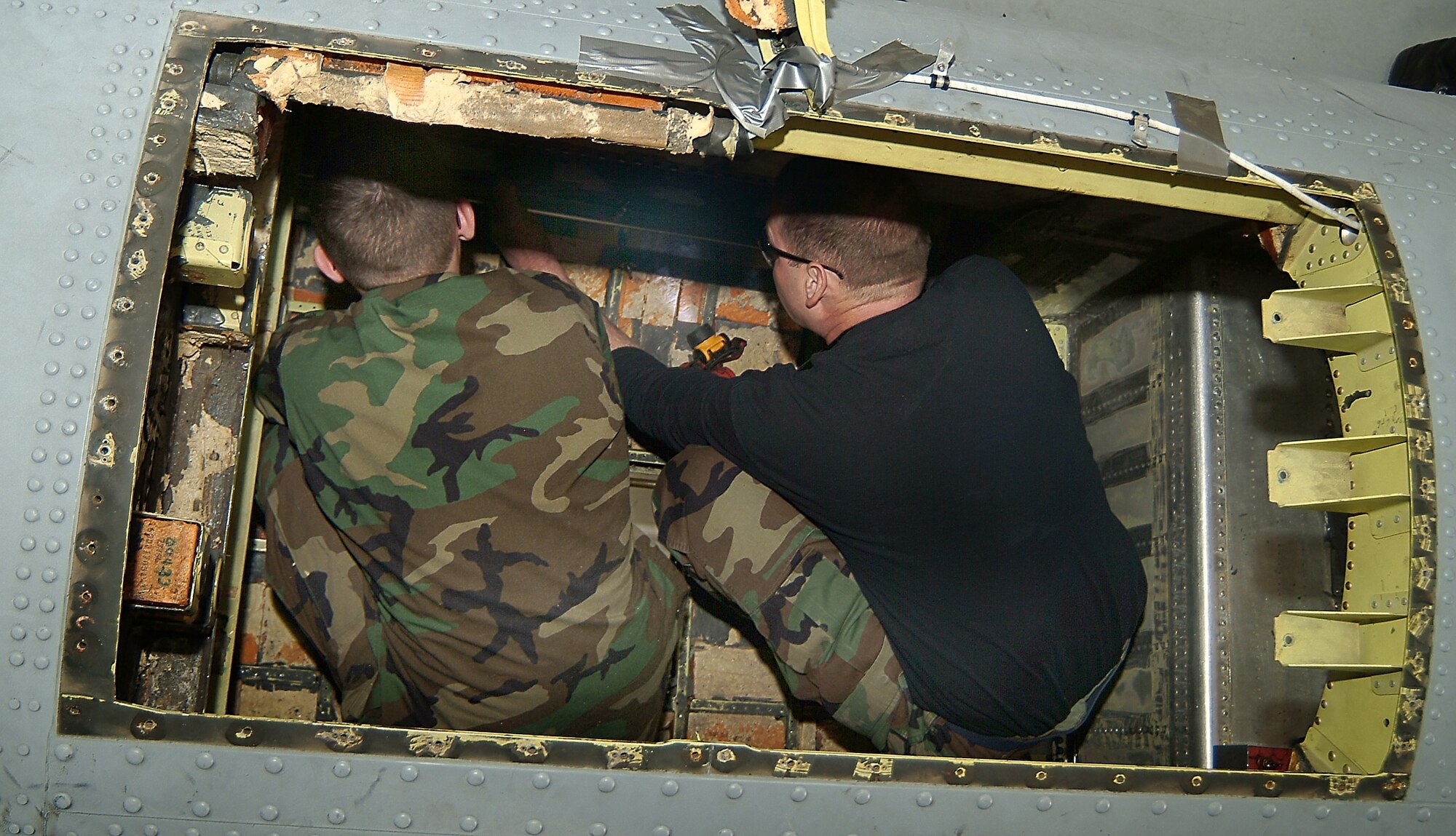 Inside the cramped confines of A-10 Thunderbolt II aircraft 237 normally filled with a fuel cell bladder, Airman Bradley Dalton and Tech. Sgt. Rick Jones, 442nd Maintenace Squadron structures shop, line up a template's screw holes with its counterpart's to verify an accurate fit for the replacement floor panel fabricated by the structures shop. The 442nd Fighter Wing reservists were tasked to remove a corrosion-degraded floor panel then fabricate and install a replacement, a task usually performed by technicians at the Ogden Air Logistics Center at Hill Air Force Base, Utah. (US Air Force photo/Master Sgt. Bill Huntington)