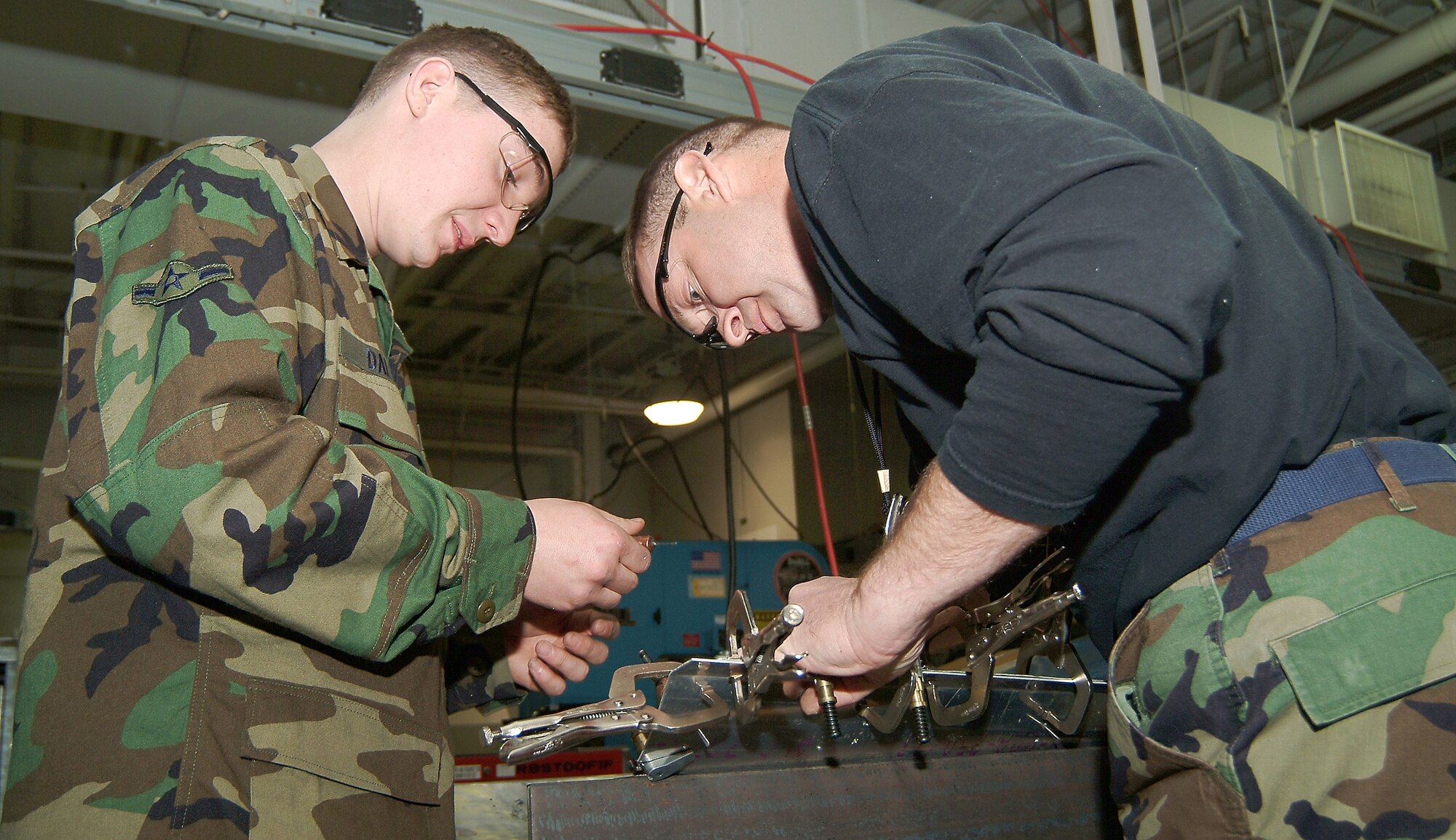 Airman Bradley Dalton and Tech. Sgt. Rick Jones, from the 442nd Maintenance Squadron's structures shop, clamp a template to a corroded floor panel  with tempoary fastners which ensure the template doesn't move during the drilling process. The 442nd Fighter Wing reservists were tasked to remove a corrosion-degraded floor panel then fabricate and install a replacement, a task usually performed by technicians at the Ogden Air Logistics Center at Hill Air Force Base, Utah. (U.S. Air Force photo/Master Sgt. Bill Huntington)