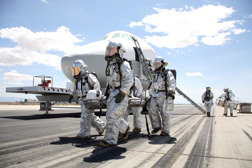 Edwards firefighters carry an "astronaut" during the space shuttle exercise here. Space Shuttle Atlantis, which will perform the STS-117 mission to the International Space Station, is scheduled to lift off in June. (Photo by Jet Fabara)

