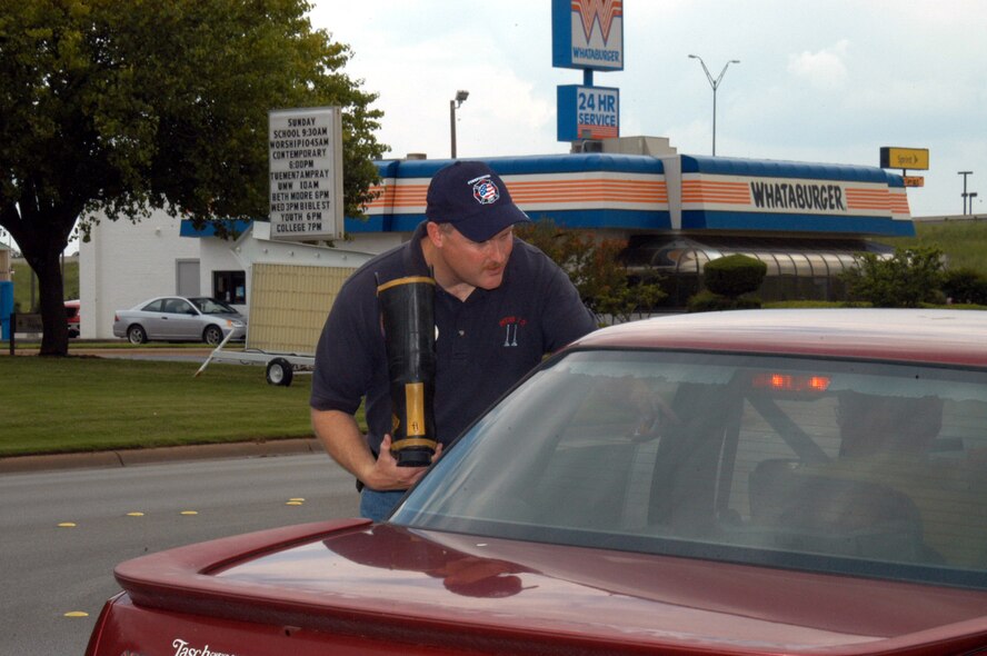 Mr. "Dallas" Cocke, 7th Civil Engineer Squadron firefighter, collects money in a boot at the intersection of Southwest Dr. and the Winters Freeway May 11. The Abilene and Dyess fire departments partnered together for a Muscular Dystrophy fund-raiser, and thanks to the local community raise $41,733 in three days. (U.S. Air Force photo by Airman 1st Class Carolyn Viss)                                         