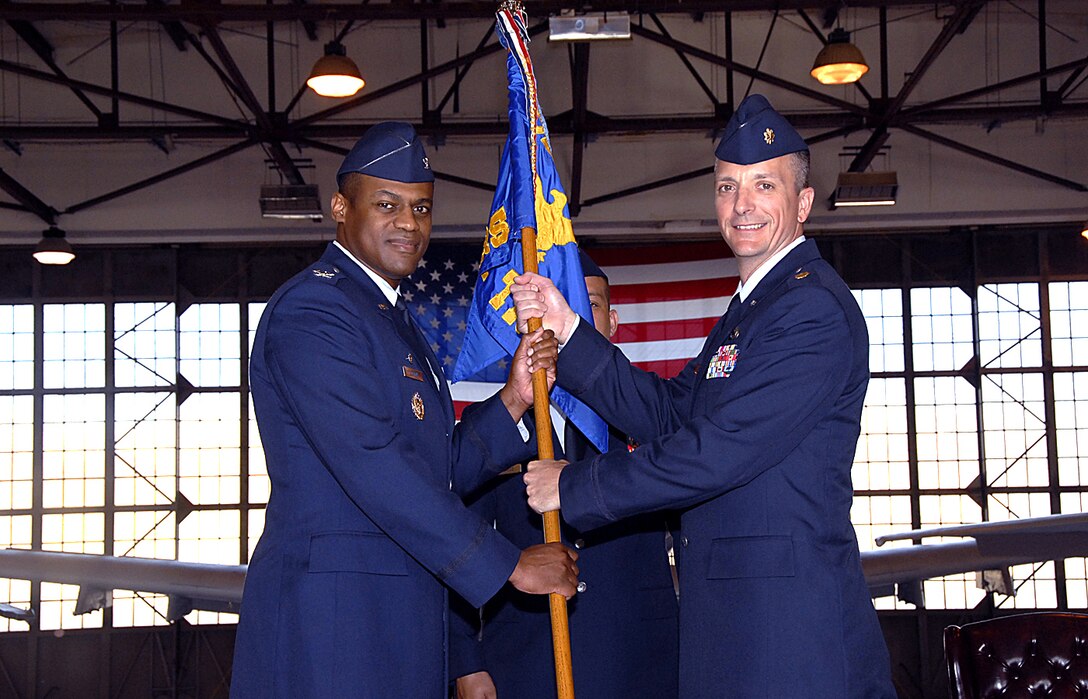Presiding officer Col. Sam Lofton III, 82nd Training Group commander, hands over the guidon to Maj. Terry Koester, new commander of the 362d Training Squadron during the formal change-of-command ceremony May 14. Major Koester replaces Lt. Col. Teal Clark as the 362nd TRS commander.  (U.S. Air Force photo/Harry Tonemah)