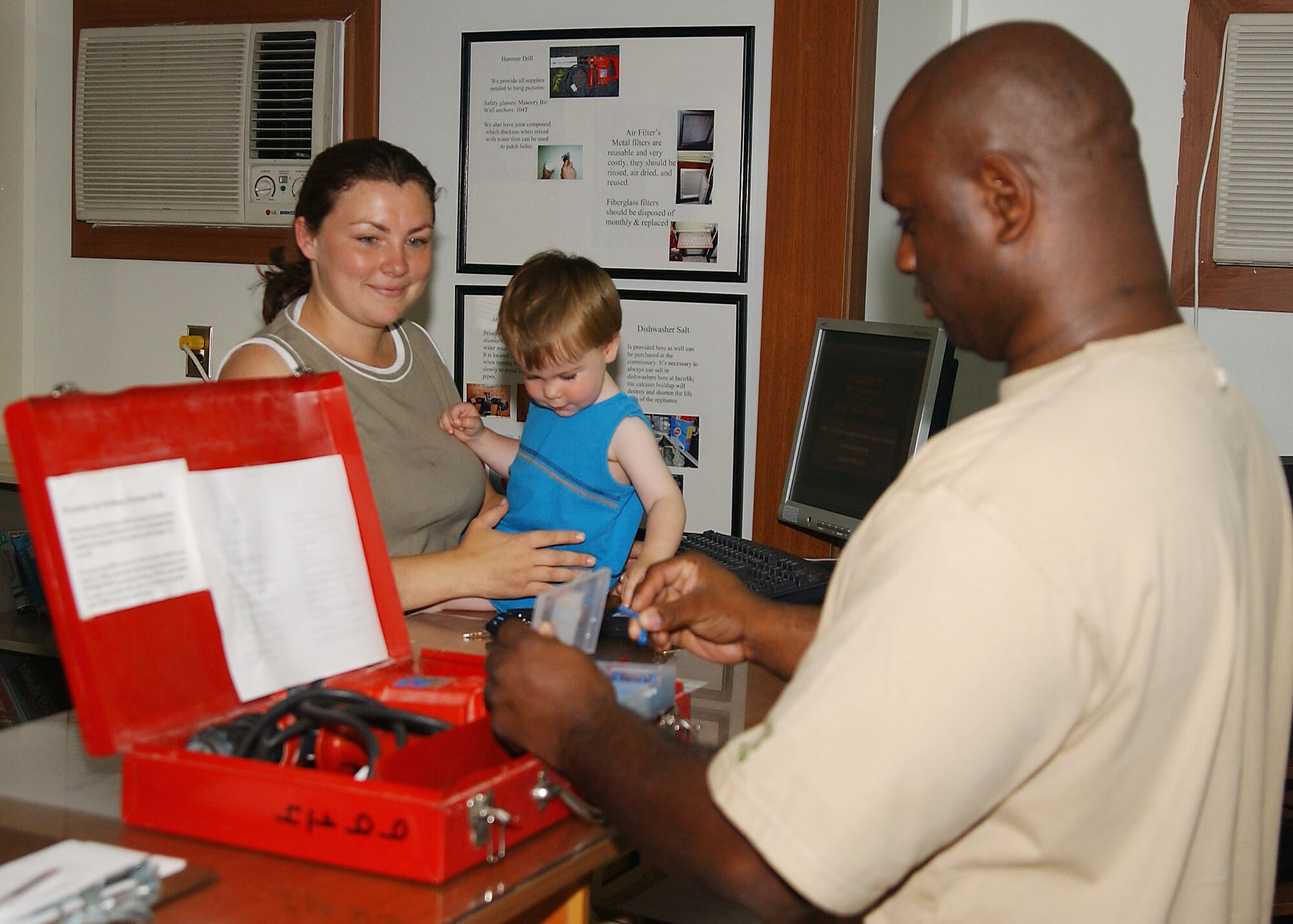 Cindy Berry, wife of Tech. Sgt. Paul Berry, 39th Communications Squadron, and their son Nicolas pick up a hammer drill for their project at the Self-Help store and sign it out with assistance of self-help employee, Derrick Covington May 7. (U.S. Air Force photo by Tech. Sgt. Patrick Hyde).