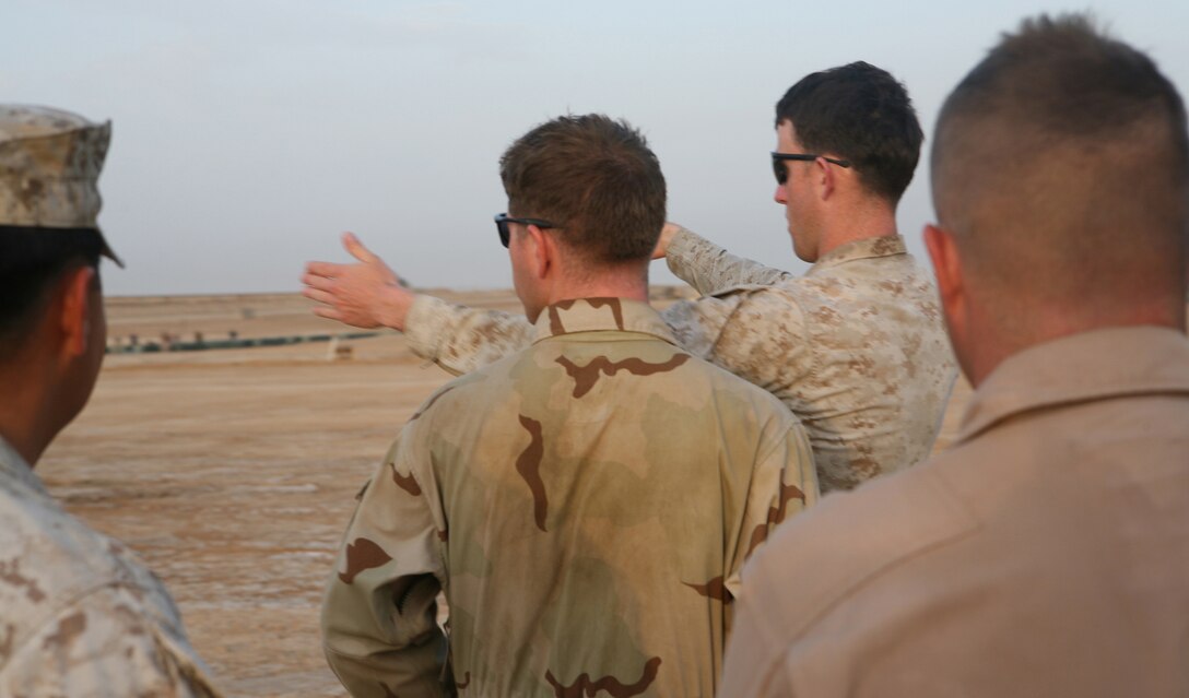 AR RAMADI, Iraq- Sgt. Randy Edwards (Center), a heavy equipment operator with Marine Wing Support Squadron 371, instructs his squad on constructing proper drainage around the helicopter refueling pad, May 17.  The heavy equipment operators arrived in Ramadi April 25 and made two helicopter landing pads and a helicopter refueling pad.
