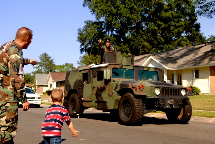 Master Sgt. Shawn Pugh, 437th Aircraft Maintainence Squadron, and his son, Austin, catch candy thrown by Lt. Col. Seth Mckee, 437 SFS commander, during a parade here May 14 to kick off Police week. (U.S. Air Force/Airman 1st Class Nicholas Pilch) 