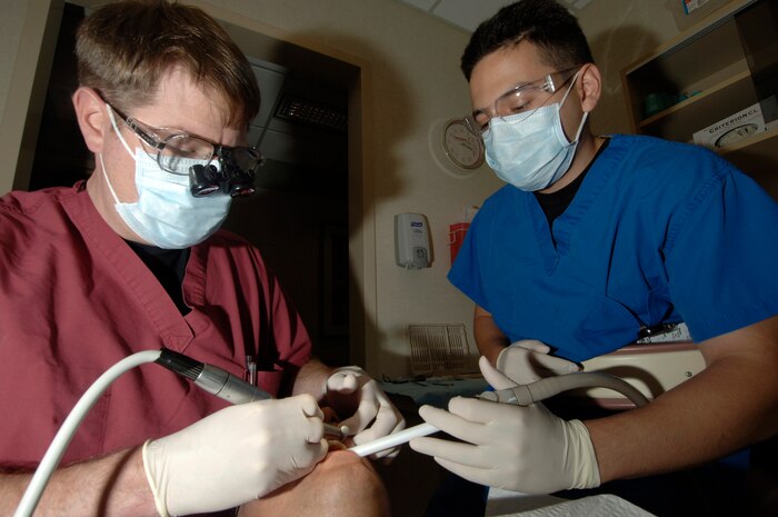 Maj. Thomas Riley, 437th Medical Group general dentist, fixes a chipped tooth on Senior Airman Matthew Anderson, 437 MDG bioenvironmental engineering technician, while assisted by Staff Sgt. Alex Garcia, 437 MDG dental assistant.  (U.S. Air Force photo/Staff Sgt. April Quintanilla)