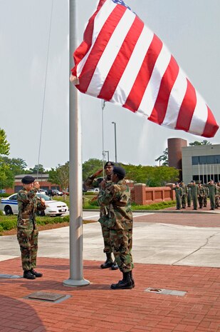 Airman 1st Class Cristy Cross, Senior Airman Terrence Bowers and Airman 1st Class Kenneth Taylor, 437th Security Forces Squadron, lower the flag during a formal retreat ceremony here May 11 as part of National Police Week. (U.S. Air Force photo/Staff Sgt. Marie Cassetty)
