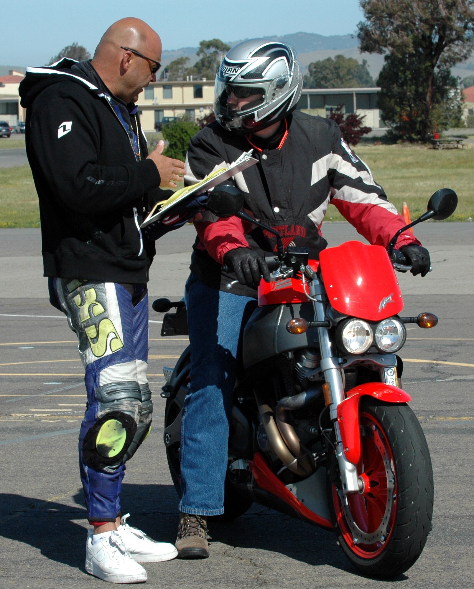 Master Sgt. Dennis Kuhn, (left), street bike safety course instructor, instructs a rider after completing the road course at Travis May 9. The class is part “classroom” teaching and part hands-on training, where the students take what they’ve learned and apply it to the course. (U.S. Air Force photo by Airman Kristen Rohrer)
