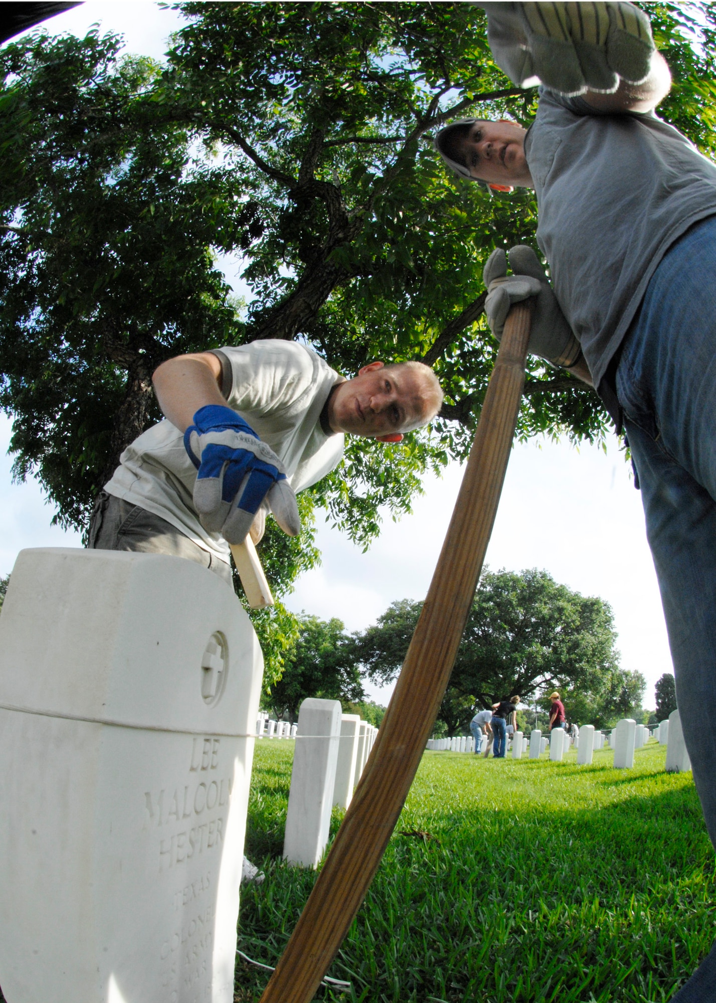 Staff Sergeants Mattew Bates (left) and Harry Kibbe  straighten headstones May 15 at the Fort Sam Houston National Cemetery in San Antonio. This process aligns and straightens all the headstones and prepares the cemetery for funerals and the upcoming Memorial Day weekend. Airmen assigned to the Air Force News Agency in San Antonio spent the day adjusting the headstones. (U.S. Air Force photo/Tech. Sgt. Larry A. Simmons)