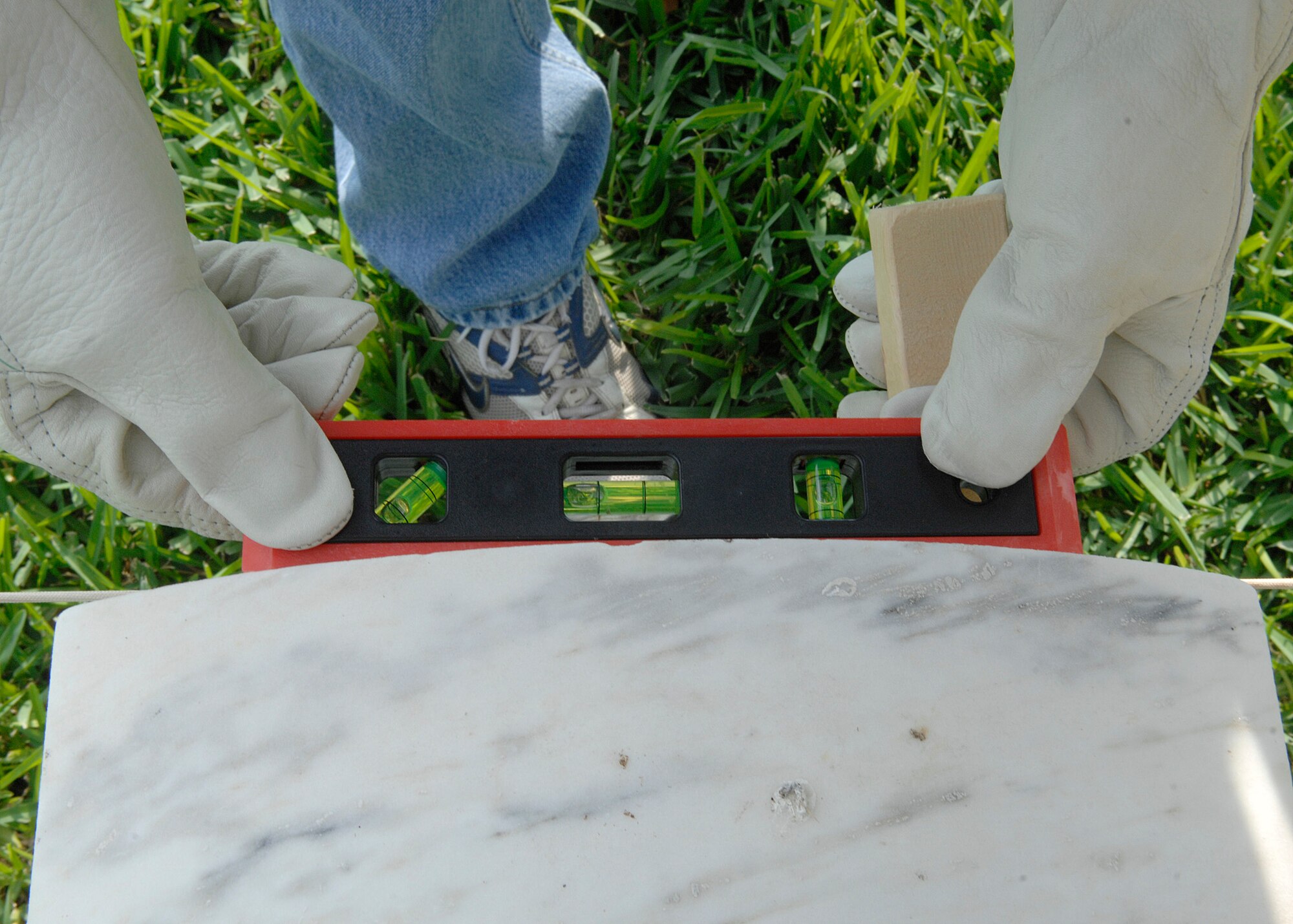 Airmen volunteers straighten headstones May 15 at the Fort Sam Houston National Cemetery in San Antonio. This process aligns and straightens all the headstones and prepares the cemetery for funerals and the upcoming Memorial Day weekend. Airmen assigned to the Air Force News Agency in San Antonio spent the day adjusting the headstones. (U.S. Air Force photo/Tech. Sgt. Larry A. Simmons)