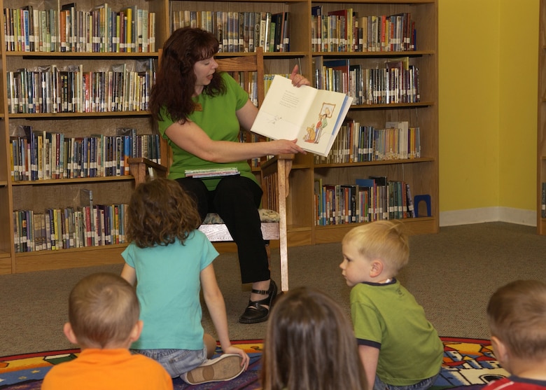 Lisa Martin, library technician, reads to Bolling children during story time at the base library May 15. The library holds story time Tuesdays at 10 a.m and Thursdays at 2 pm. Located in Building 4439 on Tinker Street, the library is open Monday through Friday from 10 a.m. to 8 p.m. and Saturday from noon to 5 p.m. It is closed Sundays and federal holidays. For more information, call (202) 767-5578. (U.S. Air Force photo by Airman 1st Class Sean Adams)