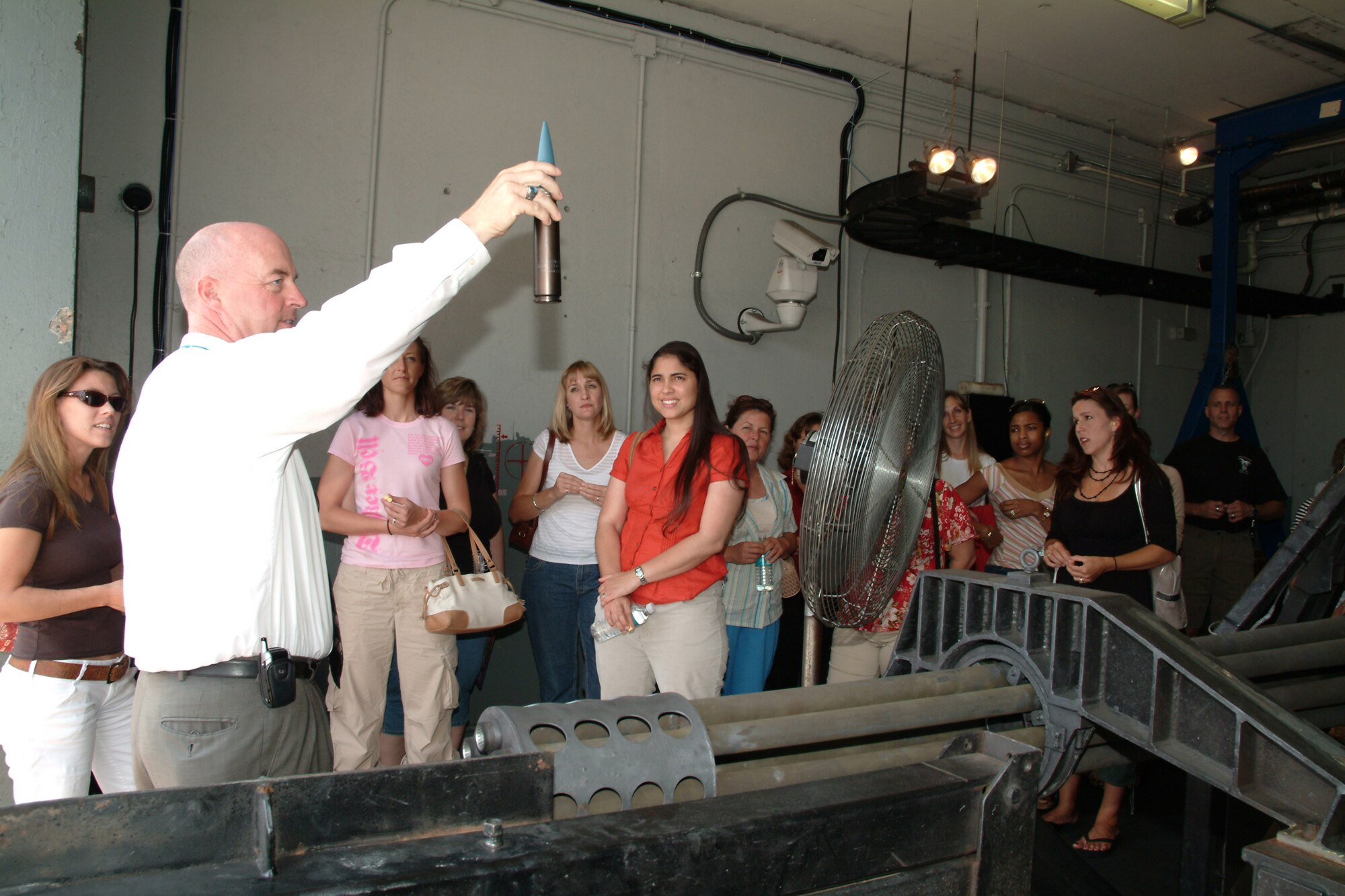 EGLIN AFB -- Kennith Osborne, Test and Evaluation specialist with the Colsa Corporation within the 780th Test Squadron, shows spouses what the 30mm bullet for the A-10 gun looks like during the 53d Wing 2007 Spouses’ Appreciation Day, May 11.  More than 70 spouses participated in the day that was geared to give spouses a chance to experience the 53d Wing’s mission and a special behind-the-scenes VIP tour, designed especially for them. The jampacked itinerary gave them a glimpse of what the unit does in the warm Florida sun as well as “chilling out” at temparatures well below freezing at the base’s McKinley Climatic Lab.  Wing spouses also visited the 85th Test and Evaluation Squadron to get a first hand look at the wing’s jets. To include experiencing the firepower of the A-10’s gun, flightline taxi rides in an F-16 and an F-15E and opportunities to fly the F-15C simulator. (U.S. Air Force photo by Tech. Sgt. Andrew Leonhard)