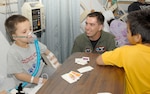 Second Lt. Brian Dudley (center), 435th Fighter Training Squadron fighter fundamentals student, spends time with children at the Methodist Hospital's Pediatric Oncology and Hematology unit recently. (U.S. Air Force photo by Don Lindsey)