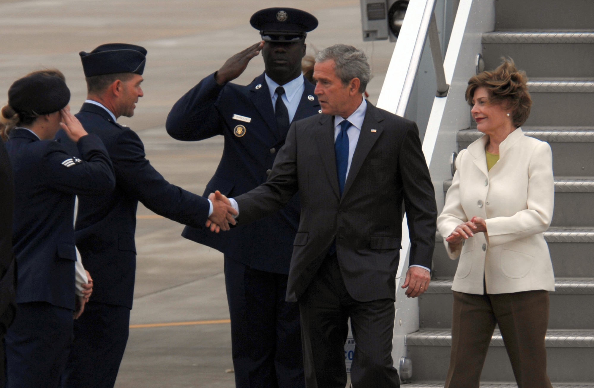 Col. Mark Barrett, 1st Fighter Wing commander, and Senior Airman Nicole O'Hara, 1st Security Forces Squadron entry controller, greet President George W. Bush and his wife, first lady Laura Bush, on their arrival here May 13. The president and his wife landed at Langley and then boarded Marine One to attend America’s Anniversary Weekend at Jamestown. (U.S. Air Force photo/Senior Airman Tabitha Kuykendall)