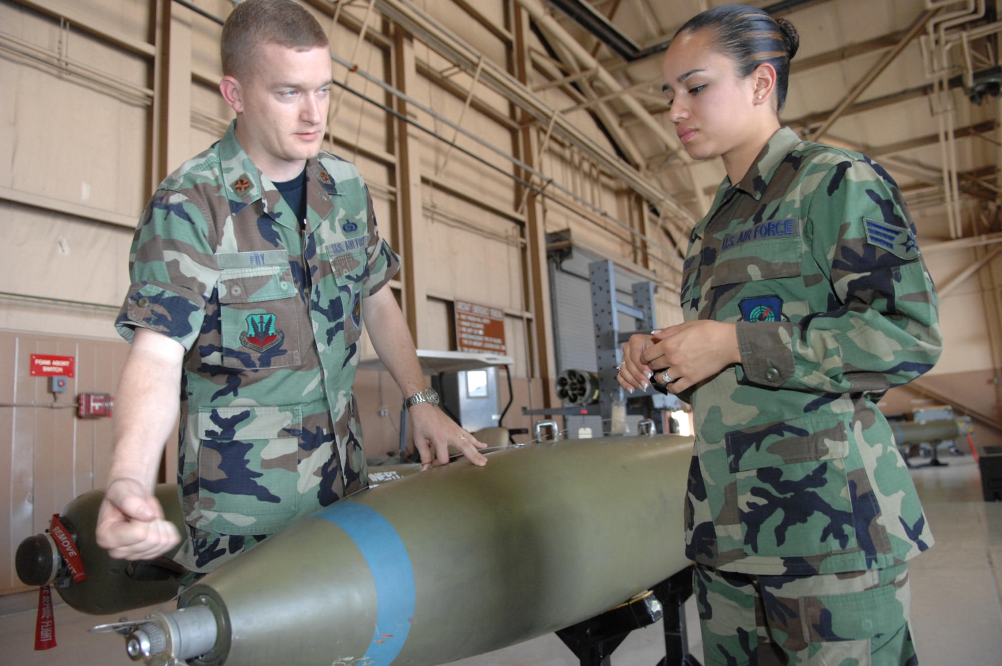Maj. William Fry, 19th Weapons School Instructor/Director of Operations, explains to Senior Airman Brandi Gilstrap about the specs on a ground to ground missle Monday May 14, 2007 Nellis AFB, Nevada.(U.S Air Force Photo by: Senior Airman Larry E. Reid Jr.)