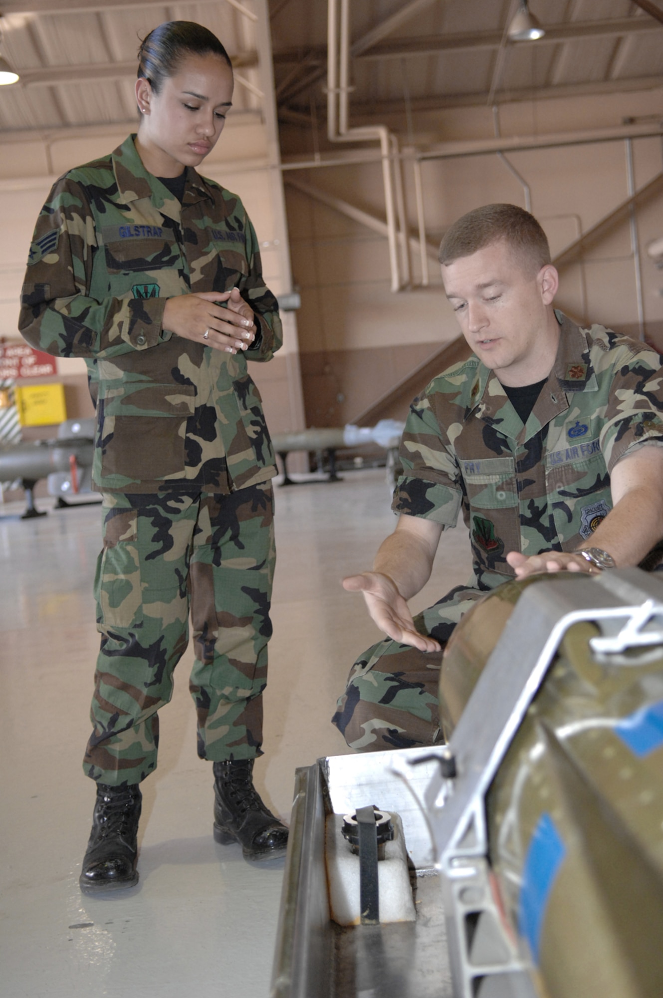Maj. William Fry, 19th Weapons School Instructor/Director of Operations, explains to Senior Airman Brandi Gilstrap about the specifics on a ground to ground missle Monday May 14, 2007 Nellis AFB, Nevada.(U.S Air Force Photo by: Senior Airman Larry E. Reid Jr.)