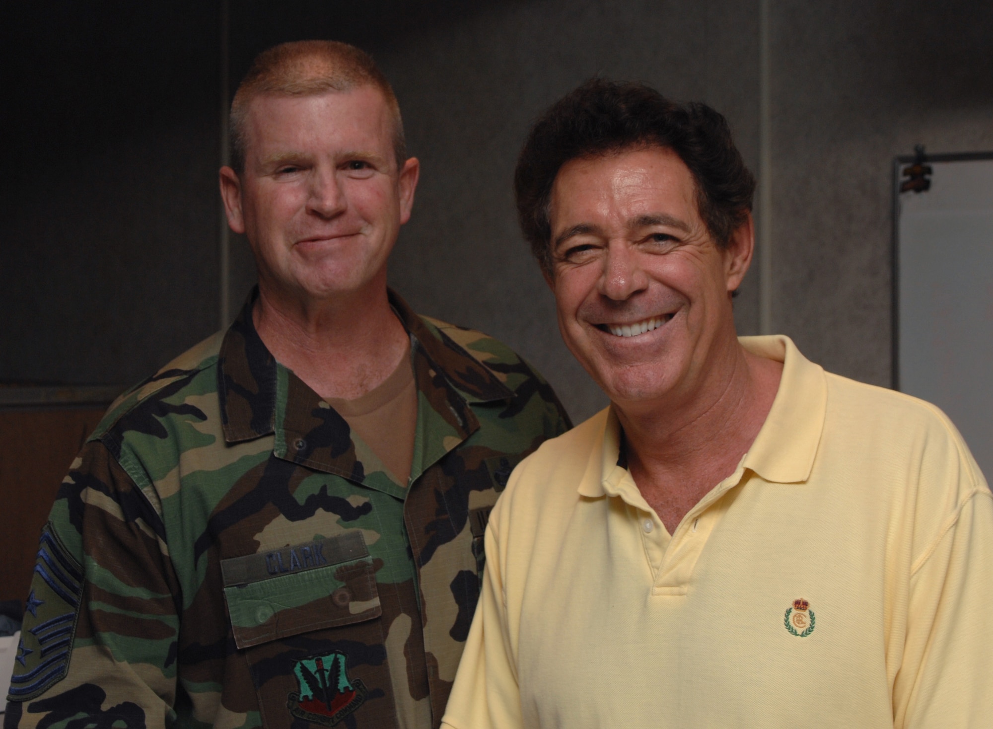 Chief Master Sgt. Layton Clark, 4th Fighter Wing command chief master sergeant, and Barry Williams, who played Greg Brady on ?The Brady Bunch? television show, pose for a photo during an autograph session for Team Seymour members and their families May 9 at the enlisted club, Seymour Johnson AFB, North Carolina.