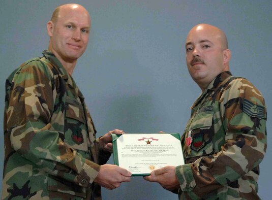 SHAW AIR FORCE BASE, S.C.-- Col. James Post, 20th Fighter Wing commander, presents Tech. Sgt. William Sistler, 20th Civil Engineer Squadron explosive ordinance disposal technician, a Bronze Star on May 11 in hangar 1200 during a commander's call. The bronze star is awarded to servicemembers who distinguished them self by heroic or meritorious achievement or service. Sergeant Sistler received the medal for his leadership of 93 missions while deployed to Iraq. His team performed safe resolution of 67 improvised explosive devices, 11 unexploded ordnance responses and two post blast analyses. The team also destroyed 9,344 ordnance items, 57,743 rounds of small arms ammunition, 192 IED components and 3,800 pounds of homemade explosives, which significantly hindered enemy forces from conducting attacks against coalition forces. (U.S. Air Force photo/Airman 1st Class Katherine McDowell)