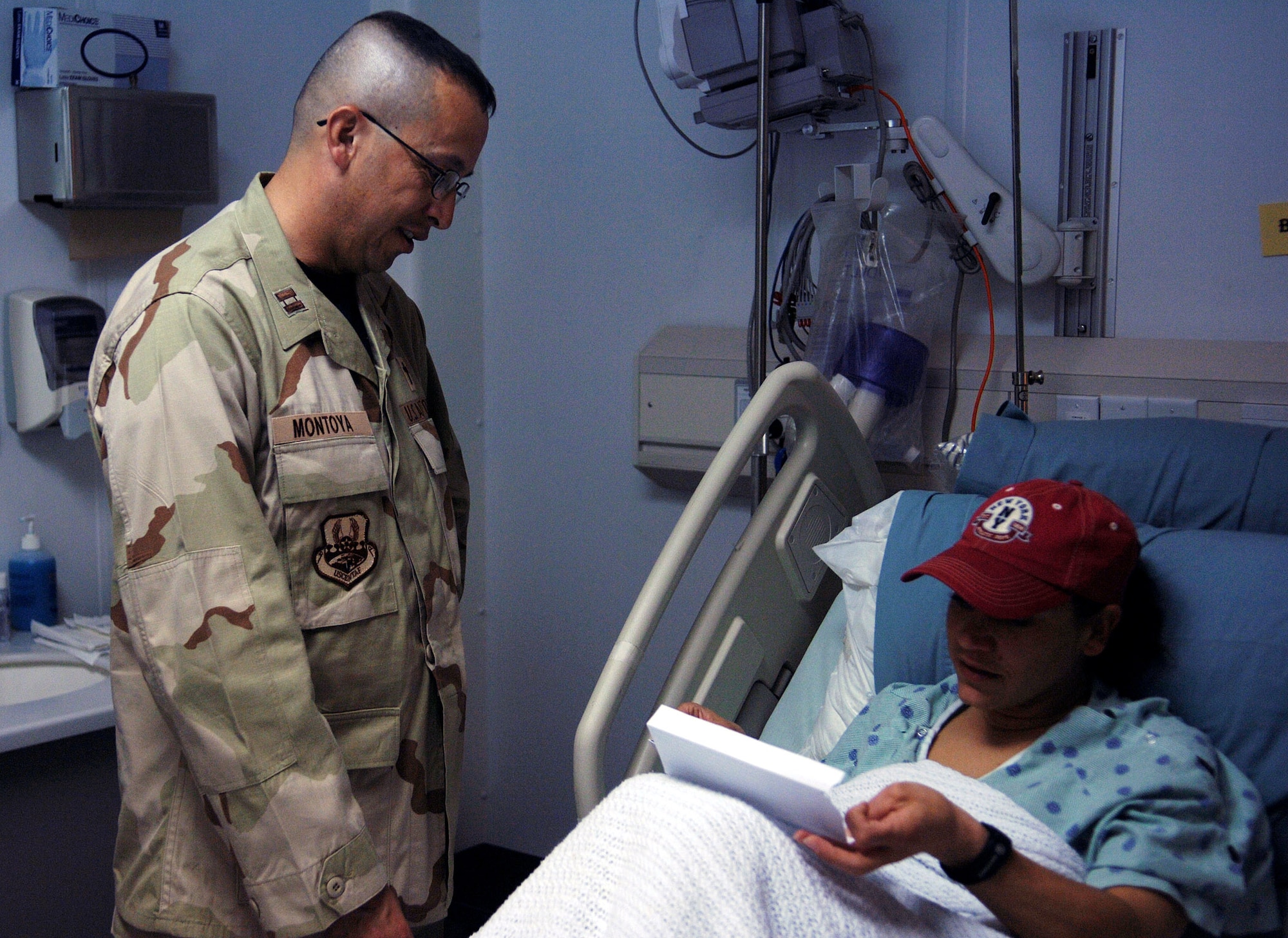 Chaplain (Capt.) Charles Montoya (left), 455th Air Expeditionary Wing chaplain, visits with Capt. Bernadette Maldonado, 455th Expeditionary Mission Support Group executive officer, at the Craig Joint Theater Hospital as she recovers from a recent operation. Chaplain Montoya is the first chaplain to be assigned directly to the 455th AEW. (photo by Capt. Nora Eyle)