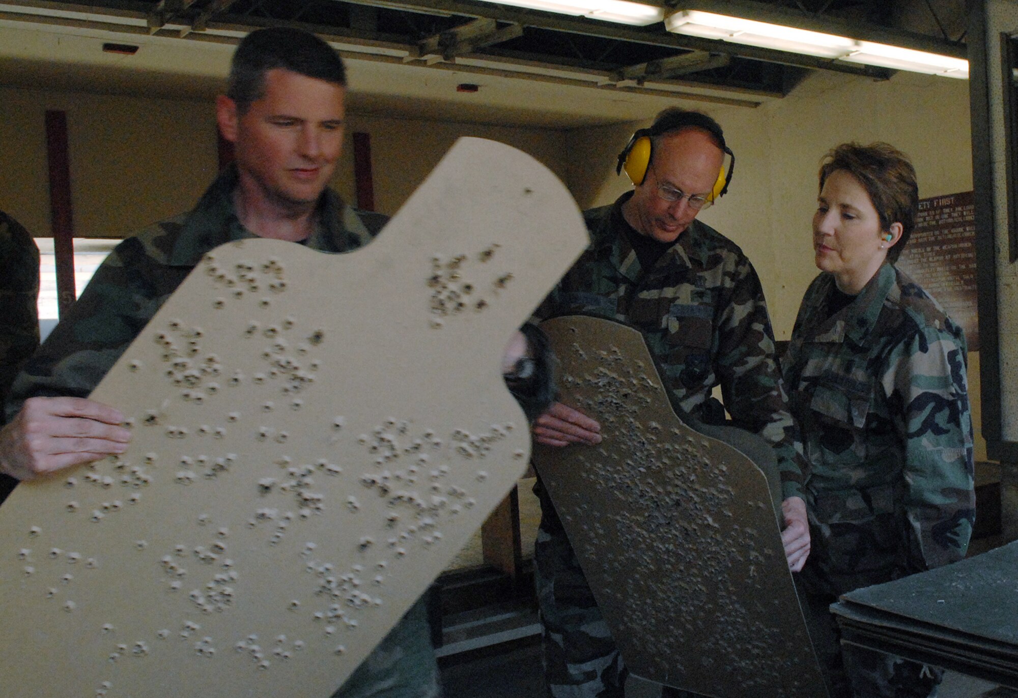 OSAN AIR BASE, Republic of Korea --  Cols. John Carter and Joel Knutson check their scores as Lt. Col. Tamara Averett-Brauer looks on during the Commanders & Chiefs Shootout on Tuesday. The winning team was Maj. Frank Schreiber and Senior Master Sgt. Samuel Abernathy, Det 2/18th Intelligence Squadron, with a combined time of 115.24 seconds. The Top Shooter for the day was Lt.Col. Daniel Runyon, 51st Munitions Squadron, with a time of 41 seconds. (U.S. Air Force photo by Senior Airman Eunique Stevens)
