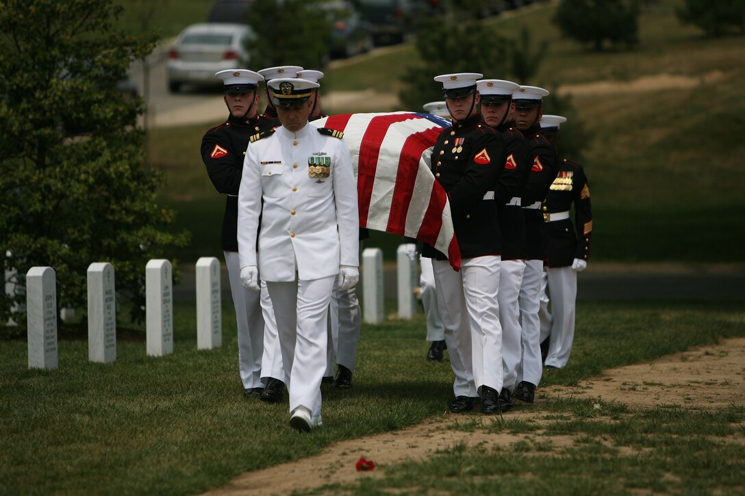 Navy chaplain Lt. Cmdr. Scott Radetski leads Marines to the final resting place for Maj. Douglas A. Zembiec, former commander of E Company, 2nd Battalion, 1st Marine Regiment.  Zembiec was laid to rest by the Marines with whom he served May 15 at Arlington National Cemetery.  Zembiec considered serving with his Marines in combat one of the greatest honors of his life.