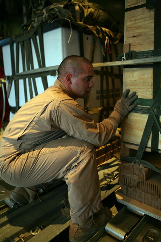AL ASAD, Iraq - Sgt. Casey Brey, a loadmaster with Marine Aerial Refueling Transport Squadron 252 Detachment A, checks to make sure a cargo delivery system bundle is properly secured in the cargo compartment of a C-130J "Hercules" before taking off from Al Asad on an air delivery mission, May 17.