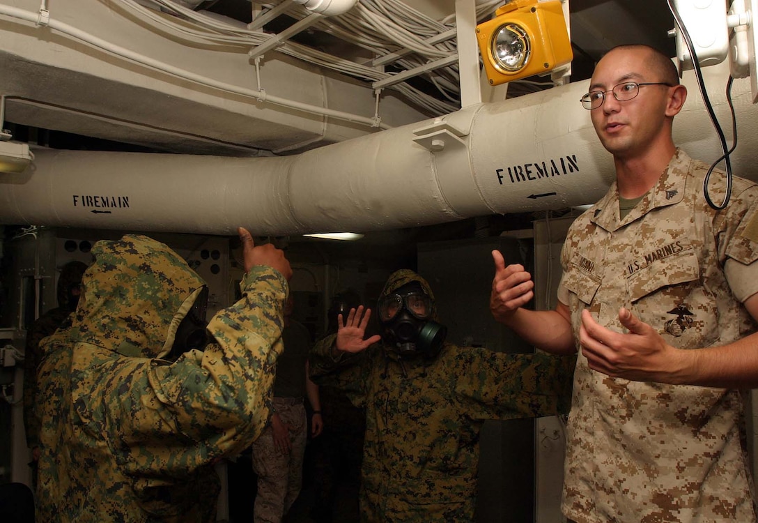 Cpl. Nicholas T. Odani (right), the chemical, biological, radiological and uclear (CBRN) chief for Headquarters and Service Company, Battalion Landing Team 2/2, 26th Marine Expeditionary Unit, gives a class on CBRN defense techniques aboard USS Bataan (LHD 5), May 17, 2007.  The Marines of BLT 2/2 have had to use creativity and organization to overcome limited training spaces aboard ship.  (Official USMC photo by Cpl. Jeremy Ross) (Released)