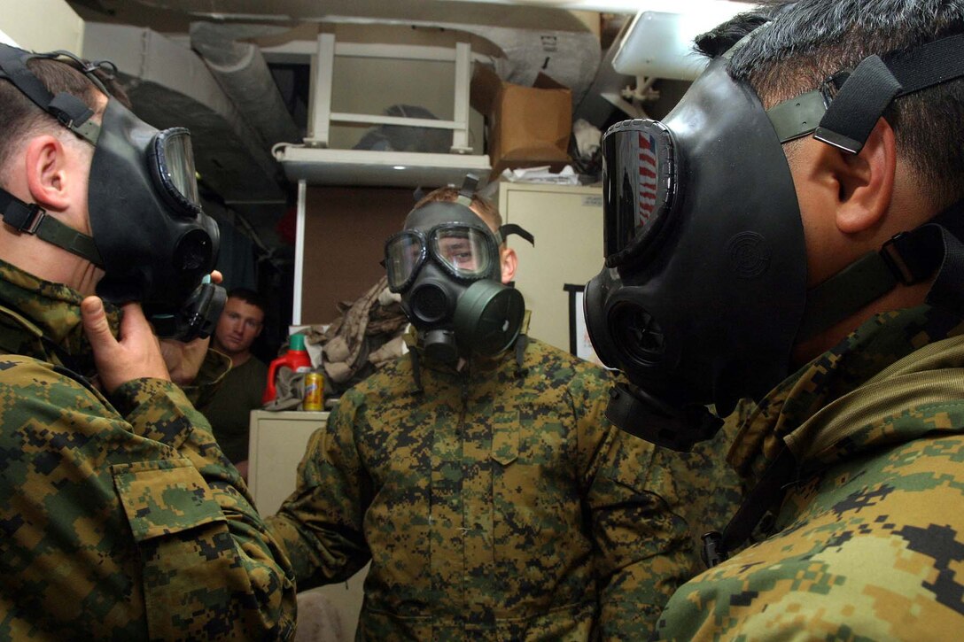 (Left to Right)  Pfc. Sean P. Ryan, Lance Cpl. Matthew D. Vanderveer and Cpl. James W. Moore, all from Weapons Company, Battalion Landing Team 2/2, 26th Marine Expeditionary Unit, conduct chemical, biological, radiological and nuclear defense training aboard USS Bataan (LHD 5), May 17, 2007.  The Marines of BLT 2/2 have had to use creativity and organization to overcome limited training spaces aboard ship.  (Official USMC photo by Cpl. Jeremy Ross) (Released)