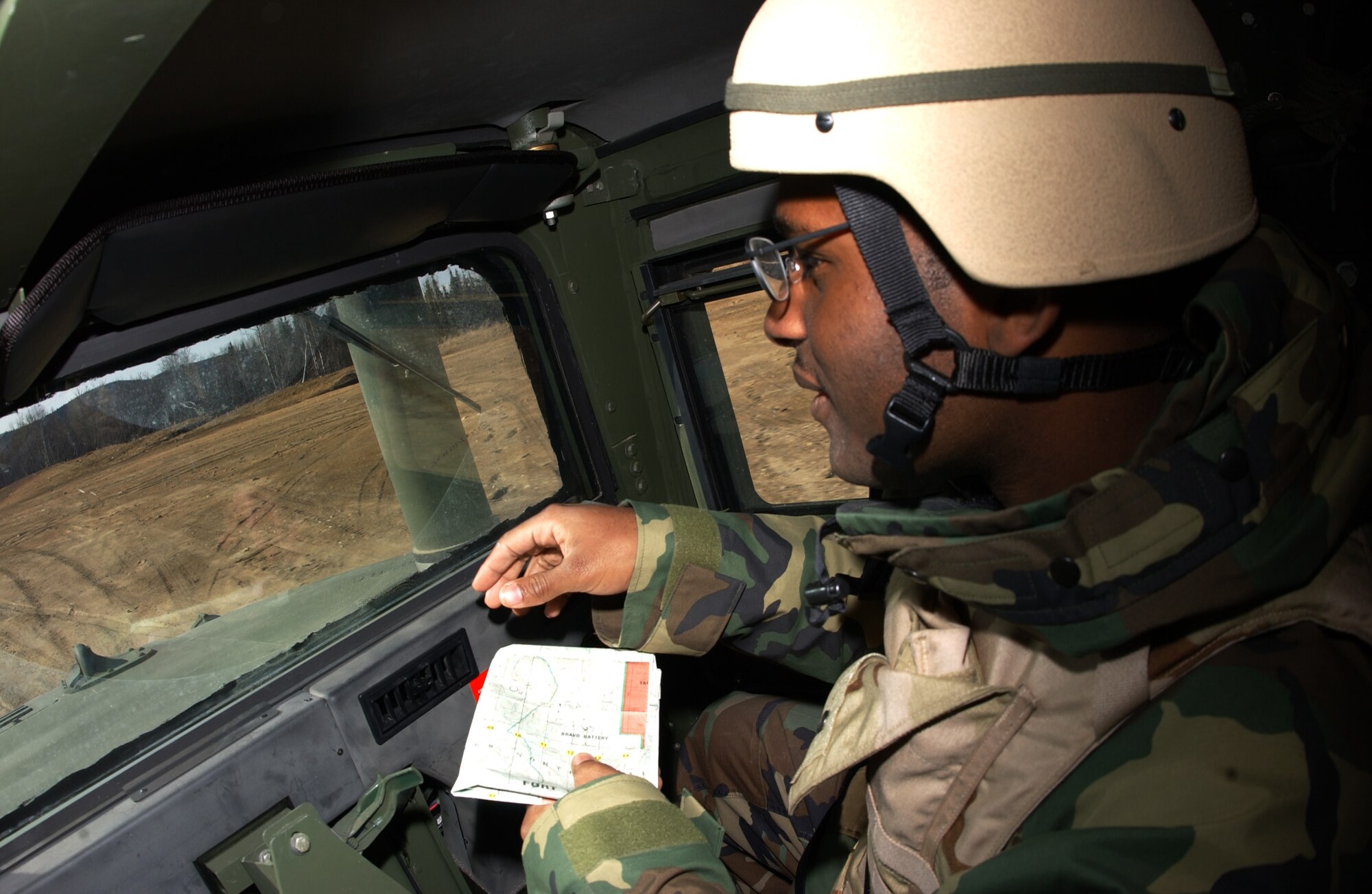EIELSON AIR FORCE BASE, Alaska -- Senior Airman Reynold Black, 3rd Air Support Operations Squadron information management, guides the Humvee driver to certain locations using a map for a vehicle navigation exercise on May 16th during Operation URSA Minor. The 3rd Air Support Operations Squadron trains, equips, and maintains mission-ready Air Liaison, Terminal Attack Control, and Weather Observation/Forecasting elements to support the U.S. Army Alaska 1st Stryker Brigade Combat Team. (U.S. Air Force Photo by Airman 1st Class Jonathan Snyder) 