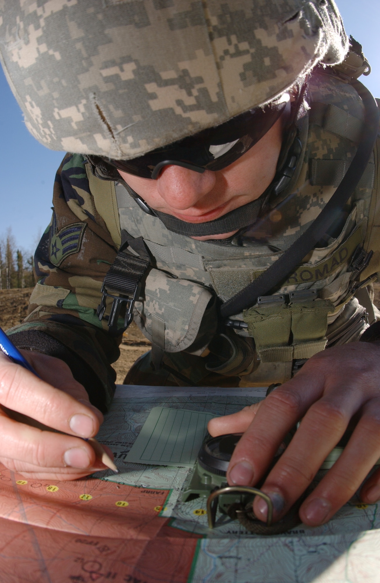 EIELSON AIR FORCE BASE, Alaska -- Senior Airman John Tranum, 3rd Air Support Operations Squadron, Tactical Air Control Party, uses a map and compass to plan his course for the vehicle navigation exercise during Operation URSA Minor May 16 on the Pacific Alaska Range Complex. The 3rd ASOS, equips, and maintains mission-ready air liaison, terminal attack control, and weather observation/forecasting elements to support the U.S. Army Alaska 1st Stryker Brigade Combat Team. (U.S. Air Force Photo by Airman 1st Class Jonathan Snyder) 