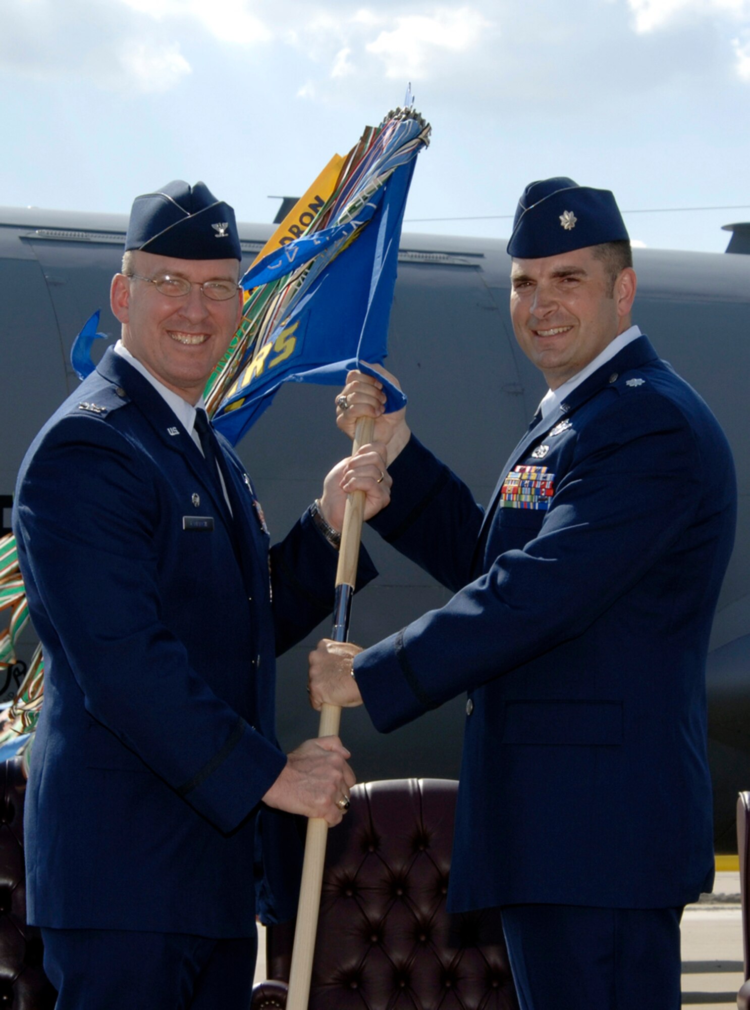 Col. Ray LaMarche, left, 22nd Operations Group commander, passes the 344th Air Refueling Wing guideon to Lt. Col. Eric Wohlrab during a change of command ceremony here May 11 during which Colonel Wohlrab assumed command of the 344th ARW. (Photo by Senior Airman Jamie Train)