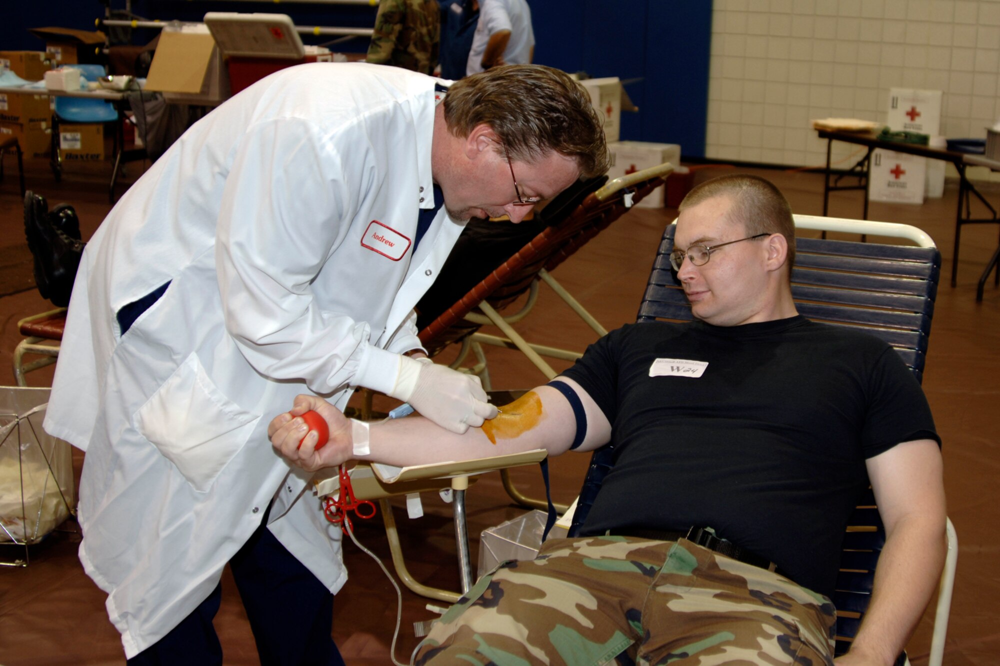 Andrew Brewer, a phlebotomist from a local chapter of the American Red Cross, draws blood from Airman 1st Class Roy Lynch, 22nd Communications Squadron May 11 during a blood drive in the fitness center gymnasium. (Photo by Senior Airman Jamie Train)