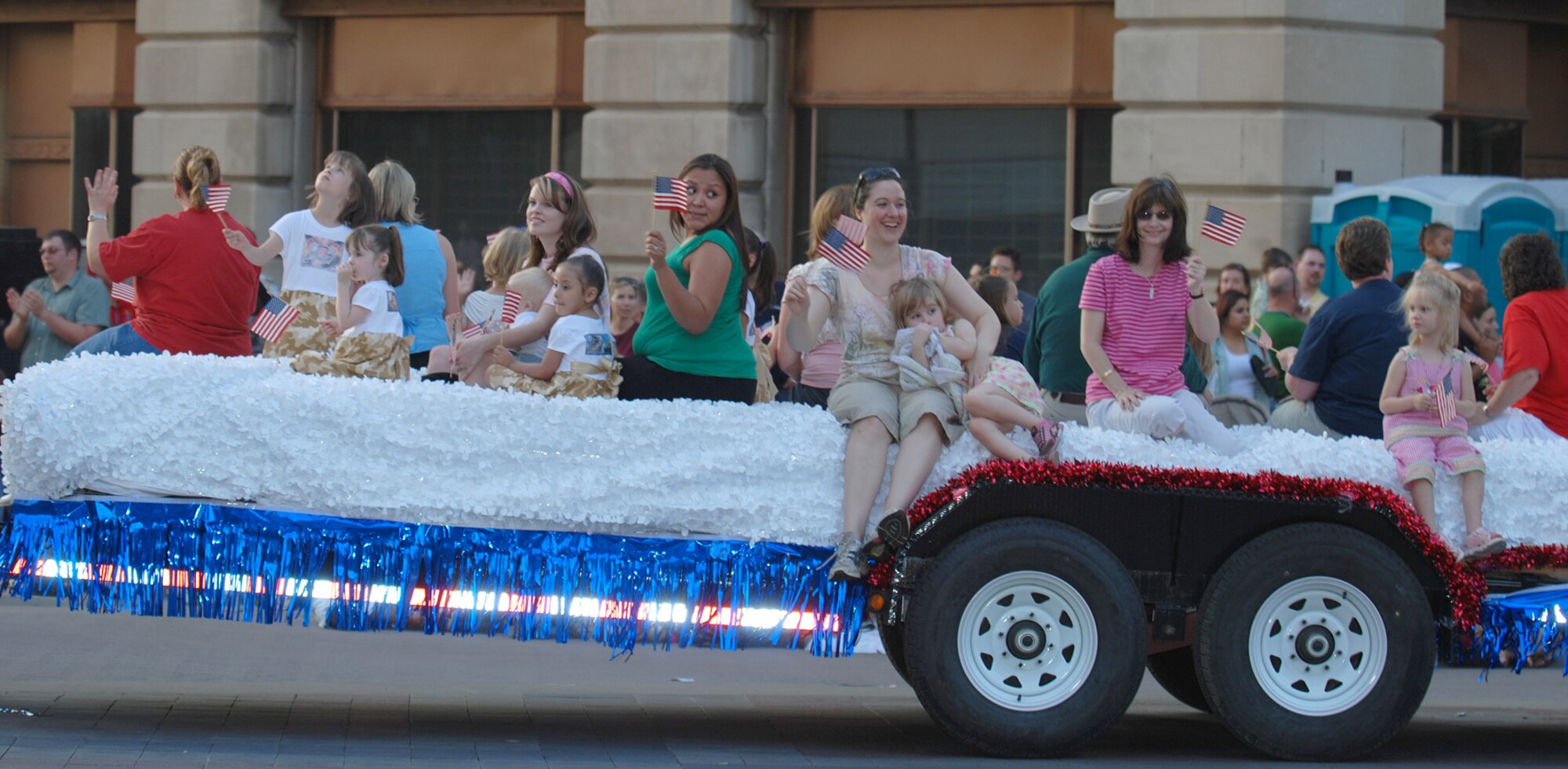 Team McConnell family members of currently deployed Airmen wave to the crowd while riding on a float during the 7th annual River Festival sundown parade in downtown Wichita, May 12. (Photo by Airman 1st Class Jessica Lockoski)