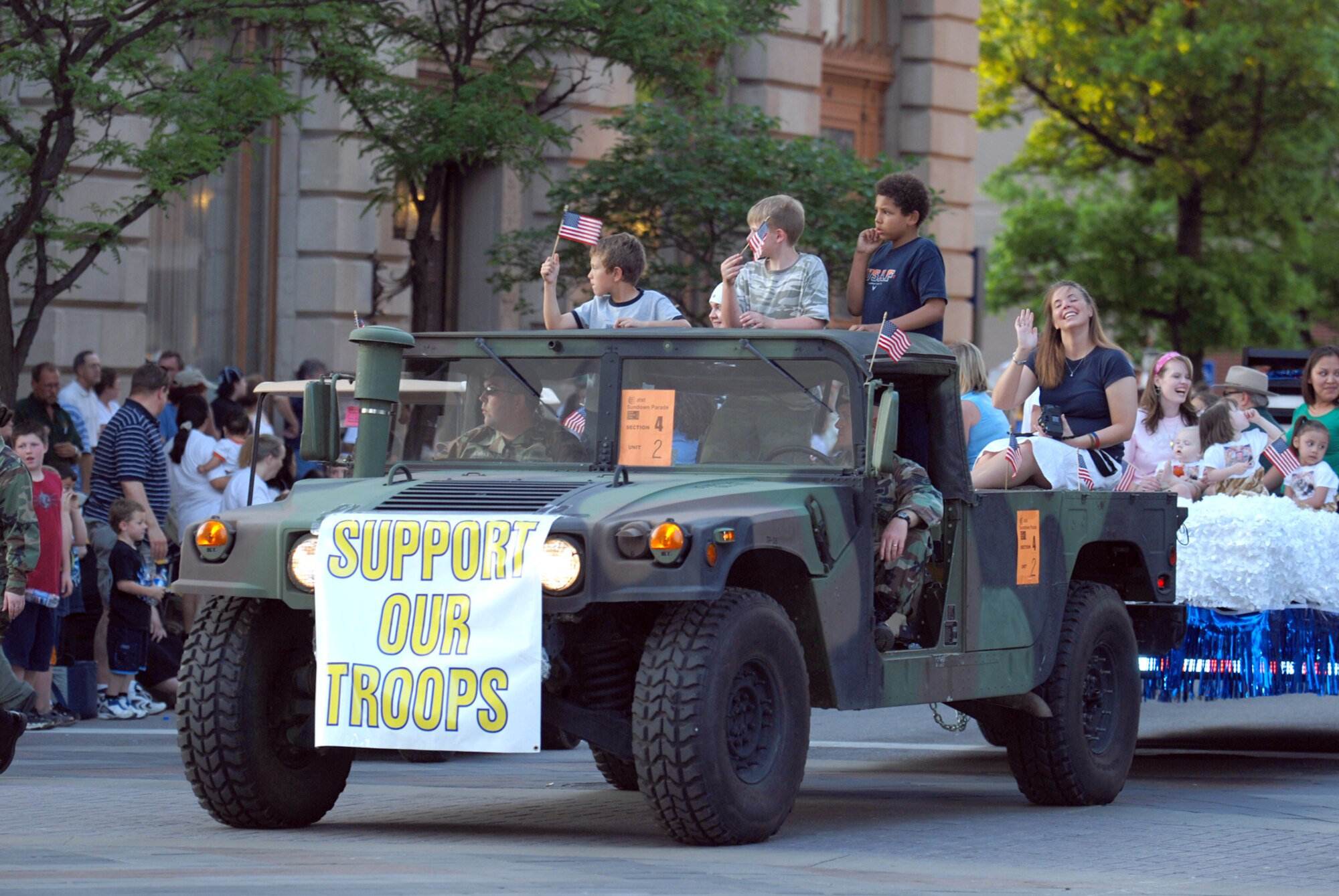 Team McConnell family members of currently deployed Airmen ride on a float towed by a 22nd Security Forces Squadron humvee during the 7th annual River Festival sundown parade in downtown Wichita, May 12. (Photo by Airman 1st Class Jessica Lockoski)