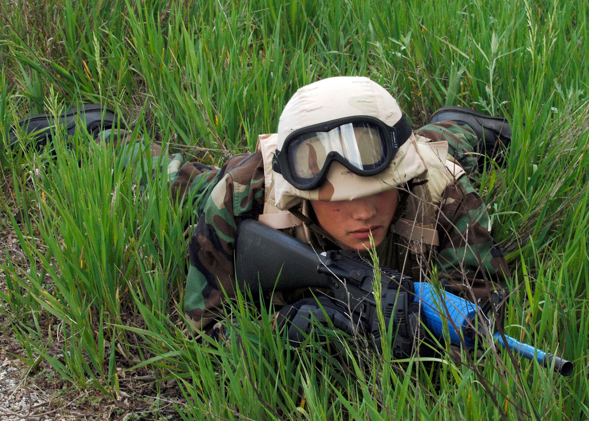 Airman Thomas Sinclair, 22nd Maintenance Squadron, lies in a prone position to avoid being seen during danger crossings during the field training portion of the Combat Skill Training course near the base obstacle course May 11. (Photo by Airman Justin Shelton) 
