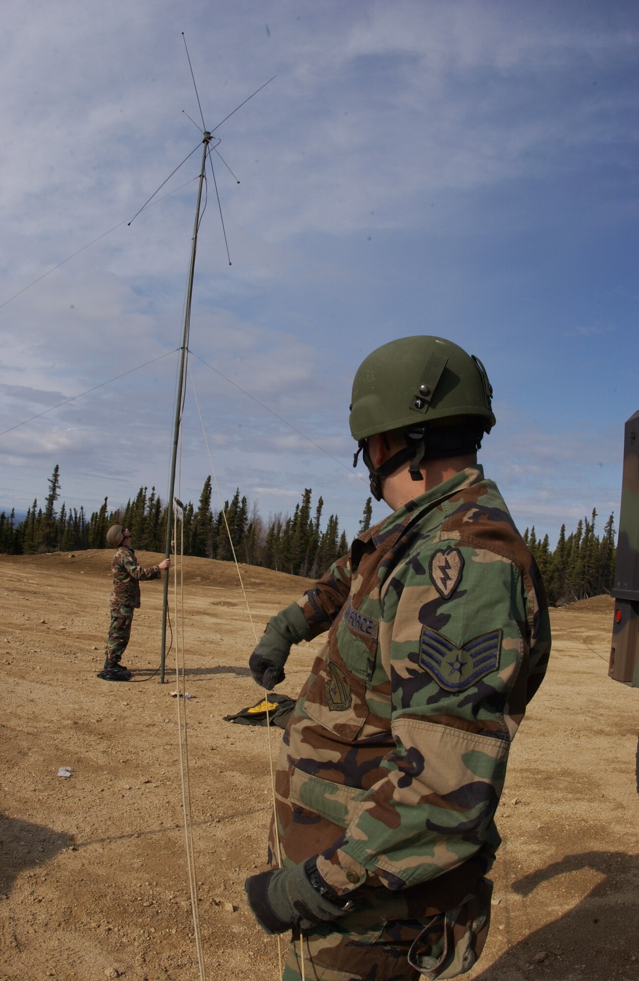 EIELSON AIR FORCE BASE, Alaska -- Staff Sgt. Richard Gustafson(Front) and Senior Airman Robert Olson(Back), 3rd Air Support Operations Squadron, erect an OE-254 FM Radio Antenna to enable communication with Army personnel May 15 during Operation URSA Minor. ASOS members completed day one of a three-day field training exercise designed to prepare Airman with hands on combat training and experience before deploying to a combat area. (U.S. Air Force Photo by Airman 1st Class Jonathan Snyder) 