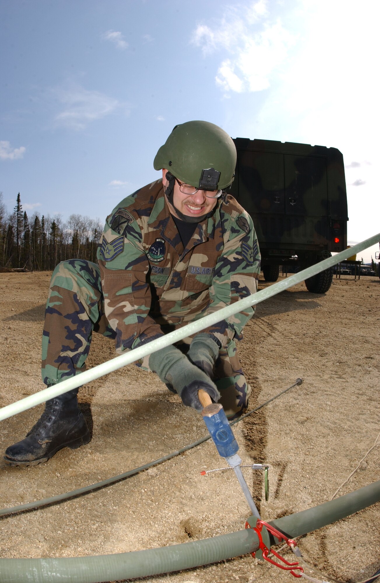 EIELSON AIR FORCE BASE, Alaska -- Staff Sgt. Richard Gustafson, 3rd Air Support Operations Squadron, pounds a stake into the ground in order to erect an OE-254 FM Radio Antenna enabling communication with Army personnel May 15 during Operation URSA Minor. ASOS members completed day one of a three-day field training exercise designed to prepare Airman with hands on combat training and experience before deploying to a combat area. (U.S. Air Force Photo by Airman 1st Class Jonathan Snyder)
