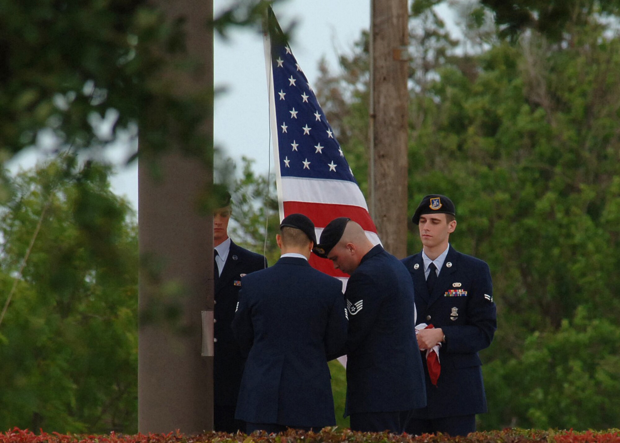 DYESS AIR FORCE BASE, Texas -- (from left to right) Airman 1st Class Cory Sanders, Staff Sgt. Nathaniel Miller, Staff Sgt. Jason Howard, and Airman 1st Class Jonathan Warnock, 7th Security Forces Squadron, fold the U.S. flag at the 21-gun salute May 15. The 21-gun salute is performed in honor of fallen military personnel and was held at Dyess in honor of National Peace Officer's Memorial Day. (U.S. Air Force photo/Airman 1st Class Felicia Juenke)