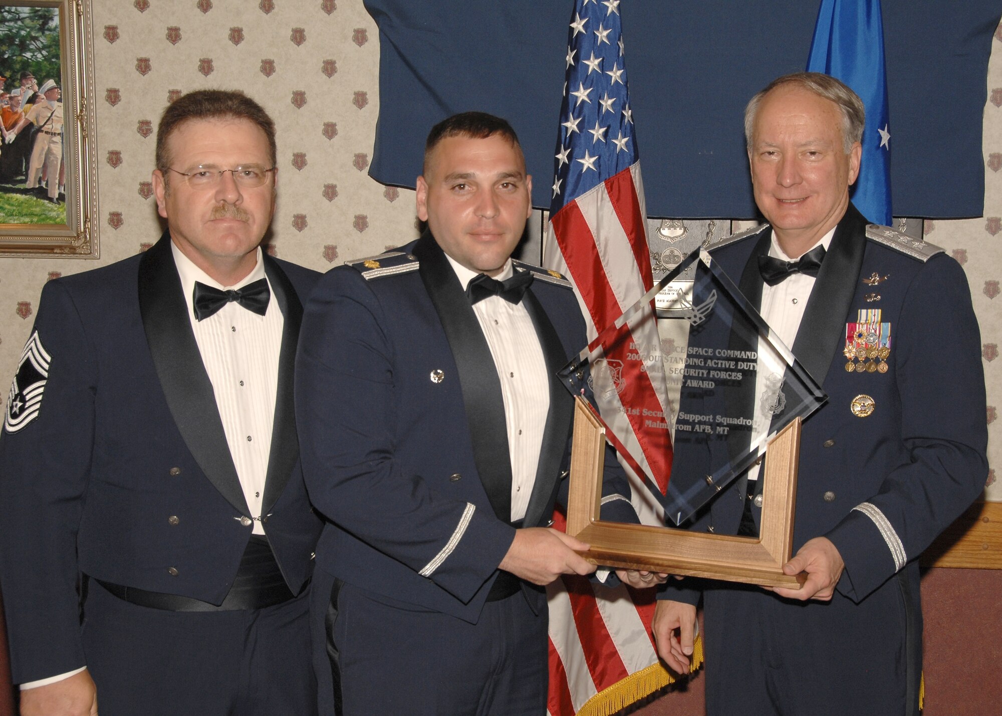 Maj. Joseph Musacchia, 341st Security Support Squadron commander, accepts the Air Force Space Command Outstanding Active Duty Small Security Forces Unit award from Lt. Gen. Frank Klotz, AFSPC vice commander. Chief Master Sgt. Larry Wilson, 341st Security Forces Group security forces manager is also pictured. (U.S. Air Force photo /  Tech. Sgt. Raheem Moore)