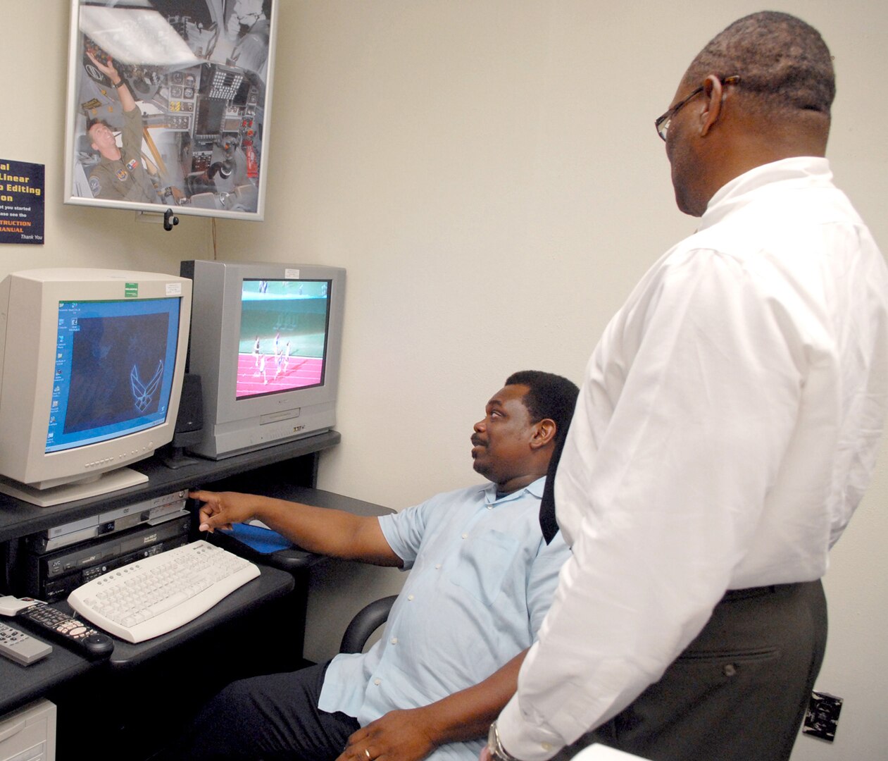 Tommy Brown (left), multimedia center graphics, shows Tony Lightner, 12th Flying Training Wing Safety, how to use the video editing kiosk.