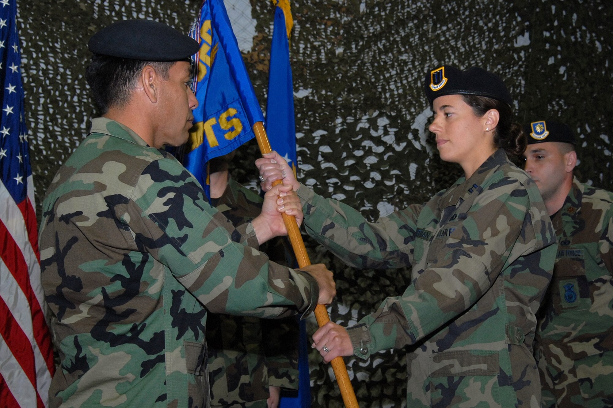 Capt. Melissa Youderian accepts the 341st SSPTS guidon from Col. Steve Asher, 341st SFG commander during a change of command ceremony Monday. Outgoing commander, Major Musacchia looks on. (U.S. Air Force photo / John Turner)