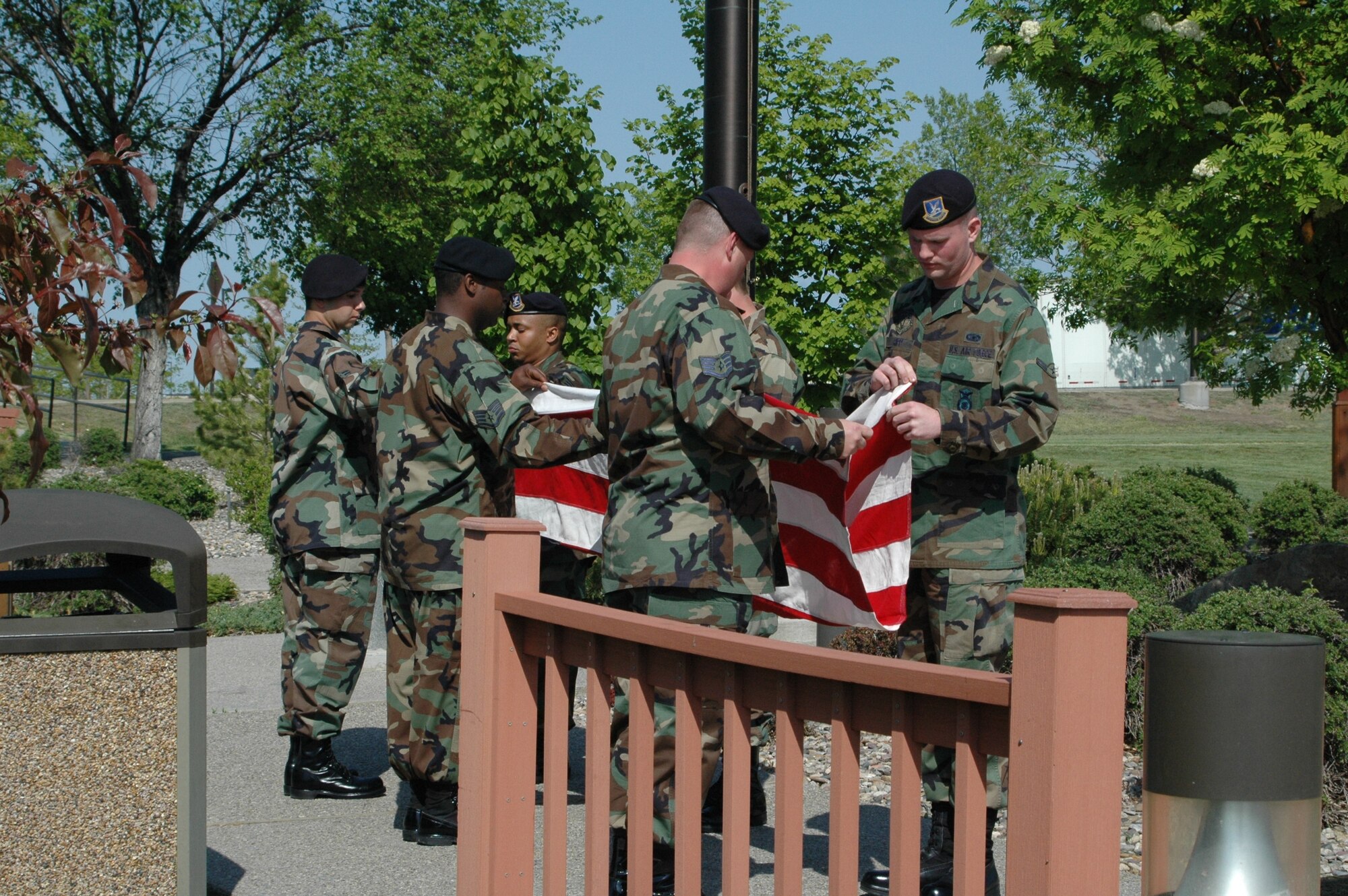 Security forces members work together to fold the flag at the memorial retreat ceremony Tuesday honoring law enforcement officers who lost their lives in the line of duty. (U.S. Air Force photo / Airman 1st Class Emerald Ralston)