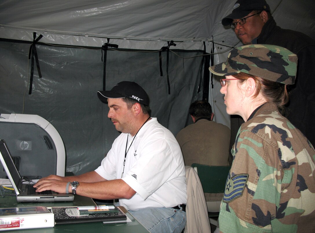 Tech. Sgt. Wendee Marshall observes Scott Thomas (sitting) and Quintin Quinn as they build a tool to share data among nations during the Combined Endeavor 2007 exercise held in Baumholder, Germany. Combined Endeavor is the largest security cooperation and communications and information systems military exercise in the world, with more than 1,200 military and civilian personnel from 42 countries and two multinational organizations. Sergeant Marshall is assigned to the 1st Combat Communications Squadron at Ramstein Air Base, Germany. (U.S. Air Force photo)