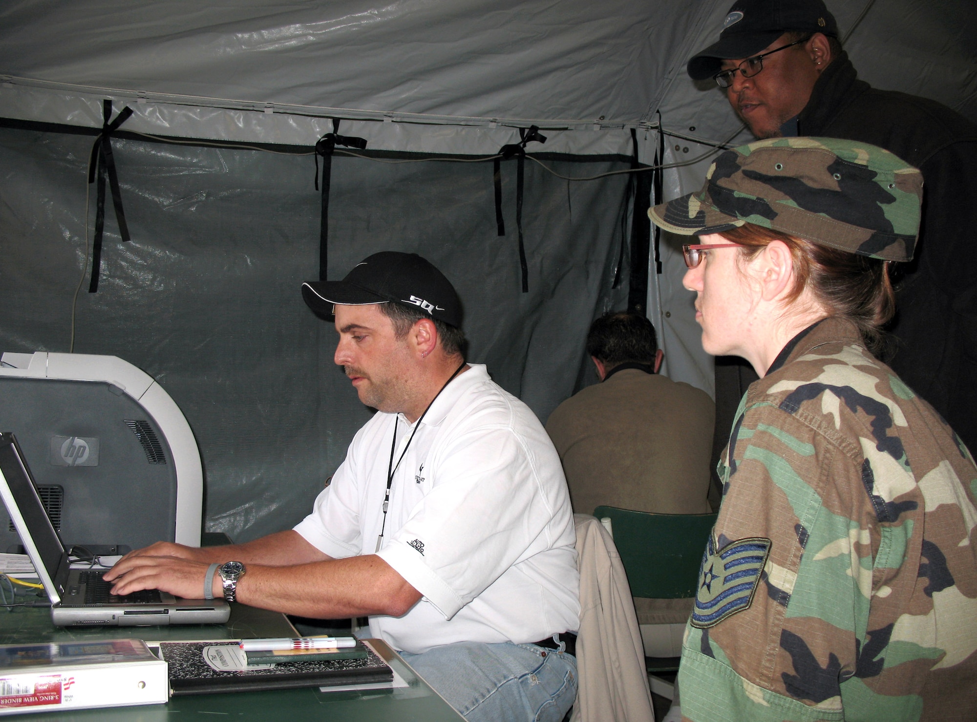 Tech. Sgt. Wendee Marshall observes Scott Thomas (sitting) and Quintin Quinn as they build a tool to share data among nations during the Combined Endeavor 2007 exercise held in Baumholder, Germany. Combined Endeavor is the largest security cooperation and communications and information systems military exercise in the world, with more than 1,200 military and civilian personnel from 42 countries and two multinational organizations. Sergeant Marshall is assigned to the 1st Combat Communications Squadron at Ramstein Air Base, Germany. (U.S. Air Force photo)