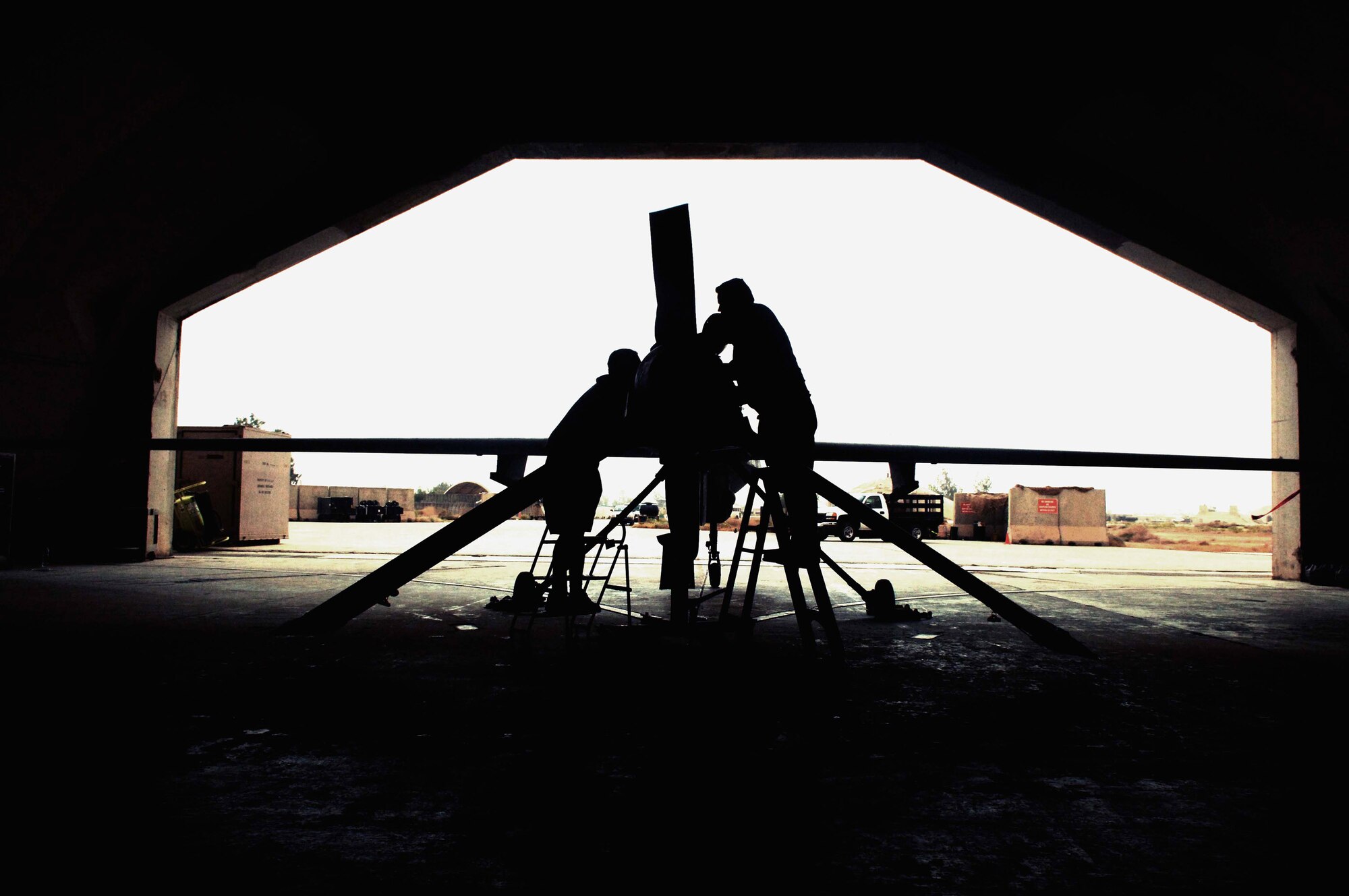 Jonathan Hagy and Russell Gordy work on an MQ-1 Predator unmanned aerial vehicle May 17 at Balad Air Base, Iraq. The Predator provides armed reconnaissance, airborne surveillance and target acquisition for coalition forces. It is a medium-altitude, long-endurance, remotely piloted aircraft. The Predator's primary mission is interdiction and conducting armed reconnaissance against critical and perishable targets. Mr. Hagy and Mr. Gordy are avionics mechanics. (U.S. Air Force photo/Airman 1st Class Jonathan Steffen)
