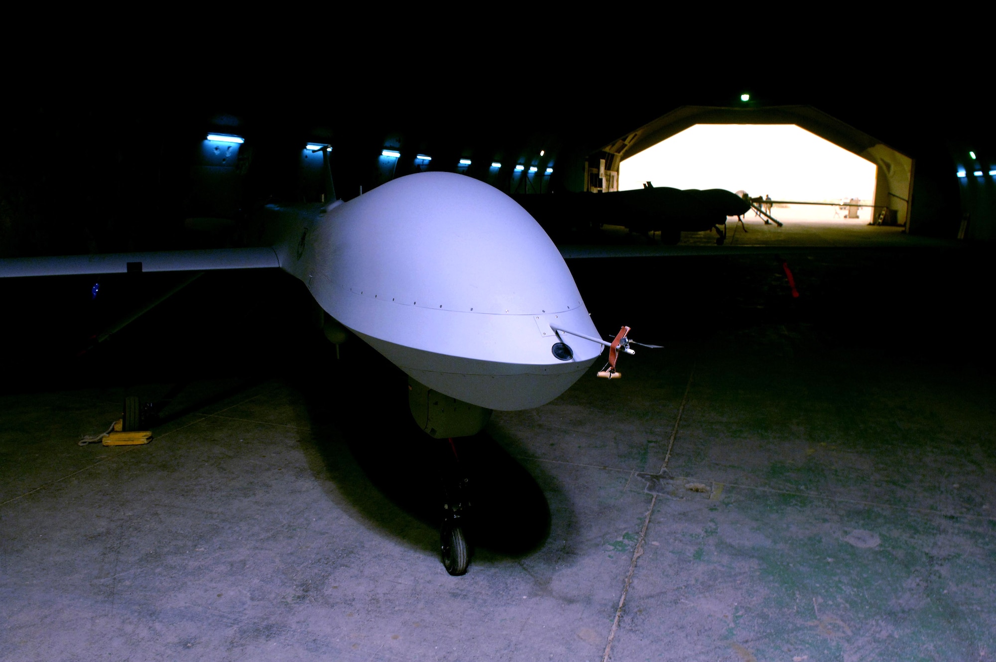 An MQ-1 Predator unmanned aerial vehicle sits in its hangar waiting for it next mission in May at Balad Air Base, Iraq. The Predator provides armed reconnaissance, airborne surveillance and target acquisition for coalition forces. The Predator carries the Multispectral Targeting System with AGM-114 Hellfire missile targeting capability and integrates electro-optical, infrared, laser designator and laser illuminator into a single sensor package. The aircraft can employ two laser-guided Hellfire anti-tank missiles with the MTS ball. (U.S. Air Force photo/Airman 1st Class Jonathan Steffen)
