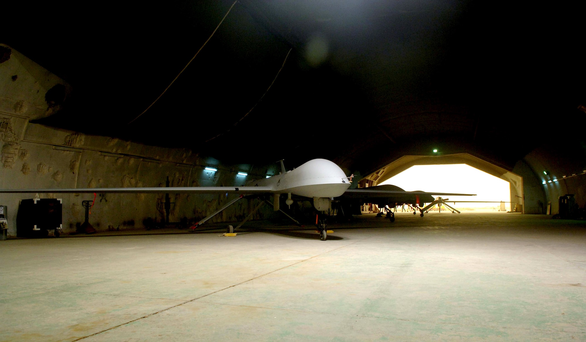 An MQ-1 Predator unmanned aerial vehicle sits in its hangar waiting for it next mission in May at Balad Air Base, Iraq. The Predator provides armed reconnaissance, airborne surveillance and target acquisition for coalition forces. The Predator carries the Multispectral Targeting System with AGM-114 Hellfire missile targeting capability and integrates electro-optical, infrared, laser designator and laser illuminator into a single sensor package. The aircraft can employ two laser-guided Hellfire anti-tank missiles with the MTS ball. (U.S. Air Force photo/Airman 1st Class Jonathan Steffen)
